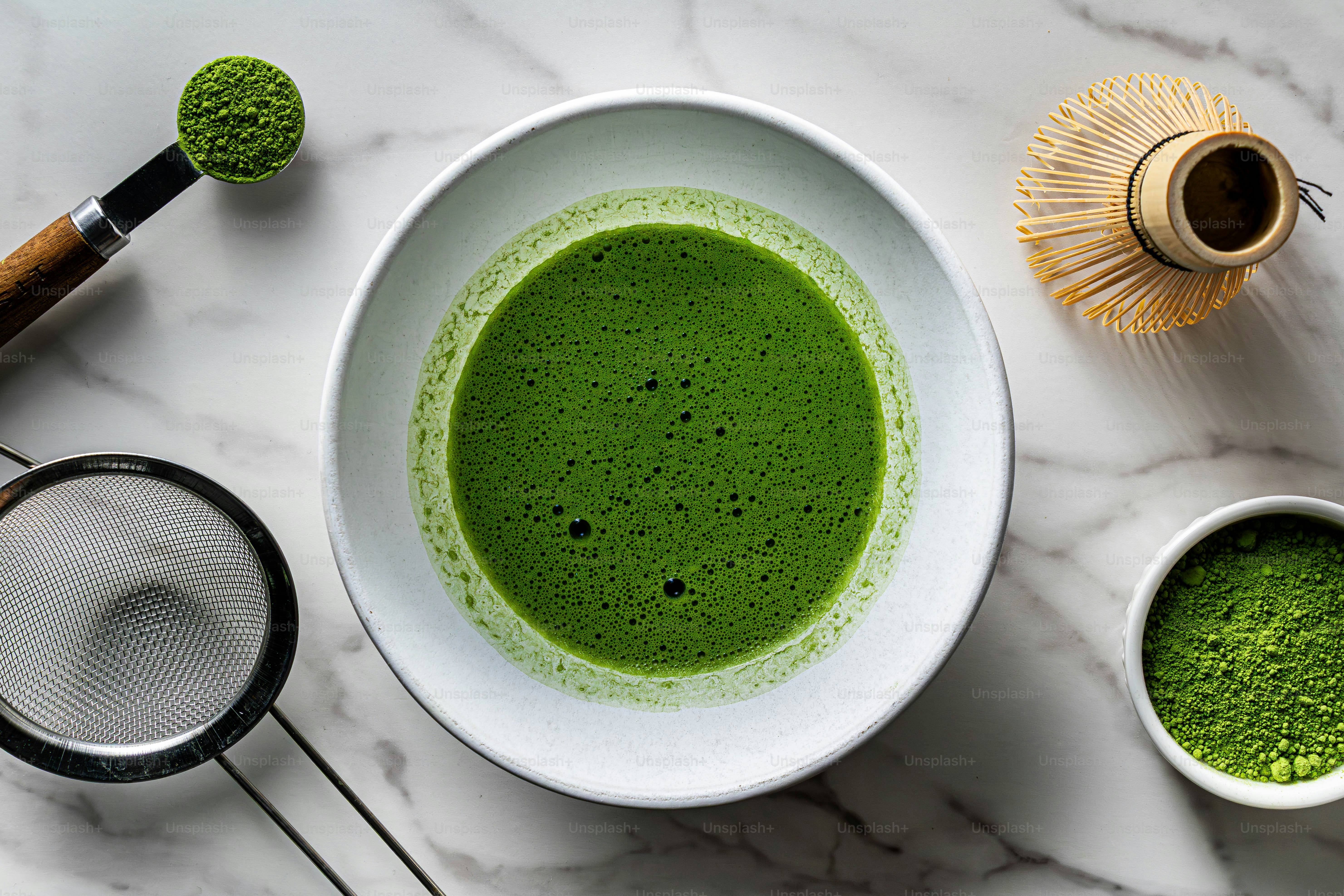 A frothy green matcha tea with a bamboo whisk photo – Natural Image on ...