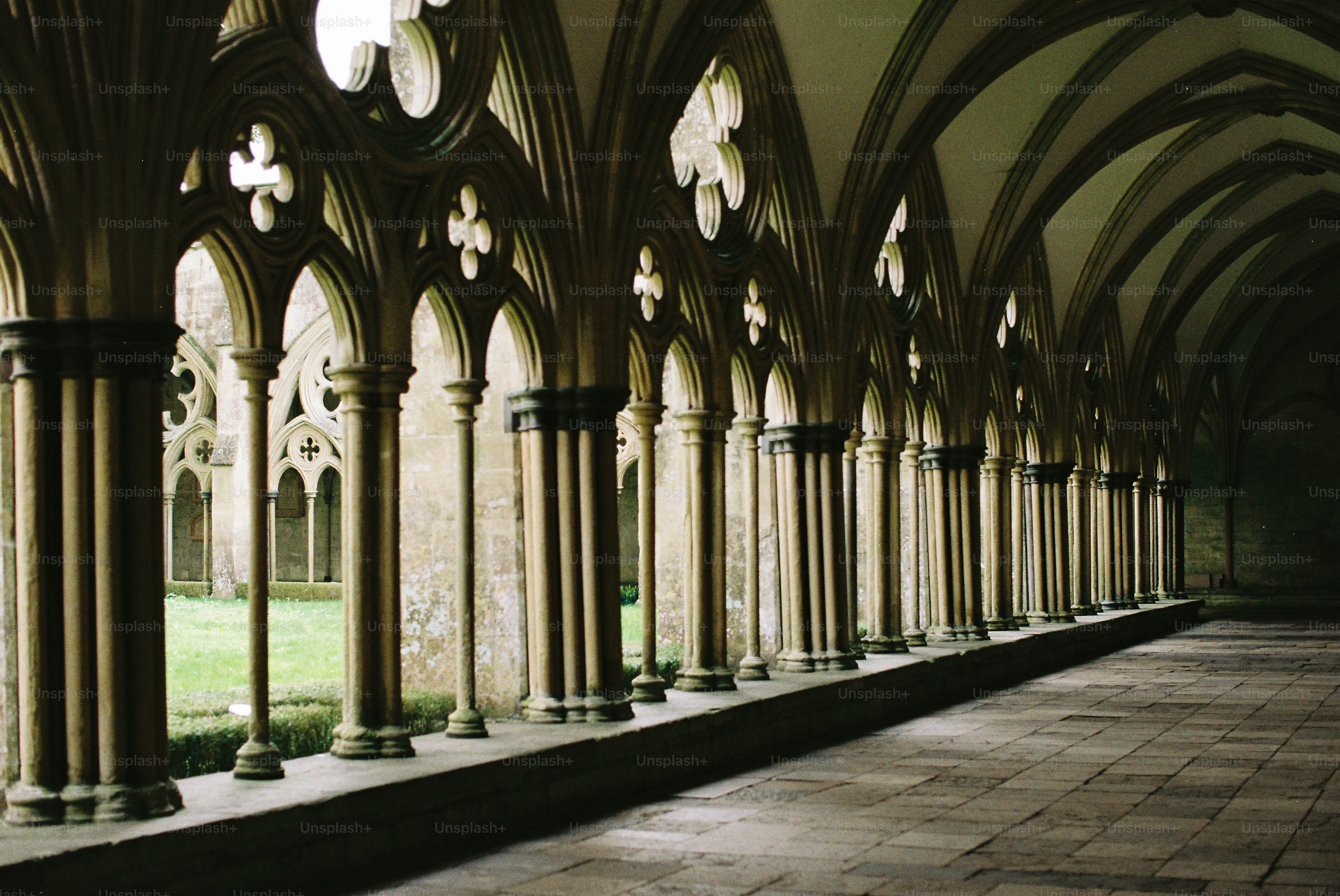 Pasillo de claustro arqueado con columnas y patio