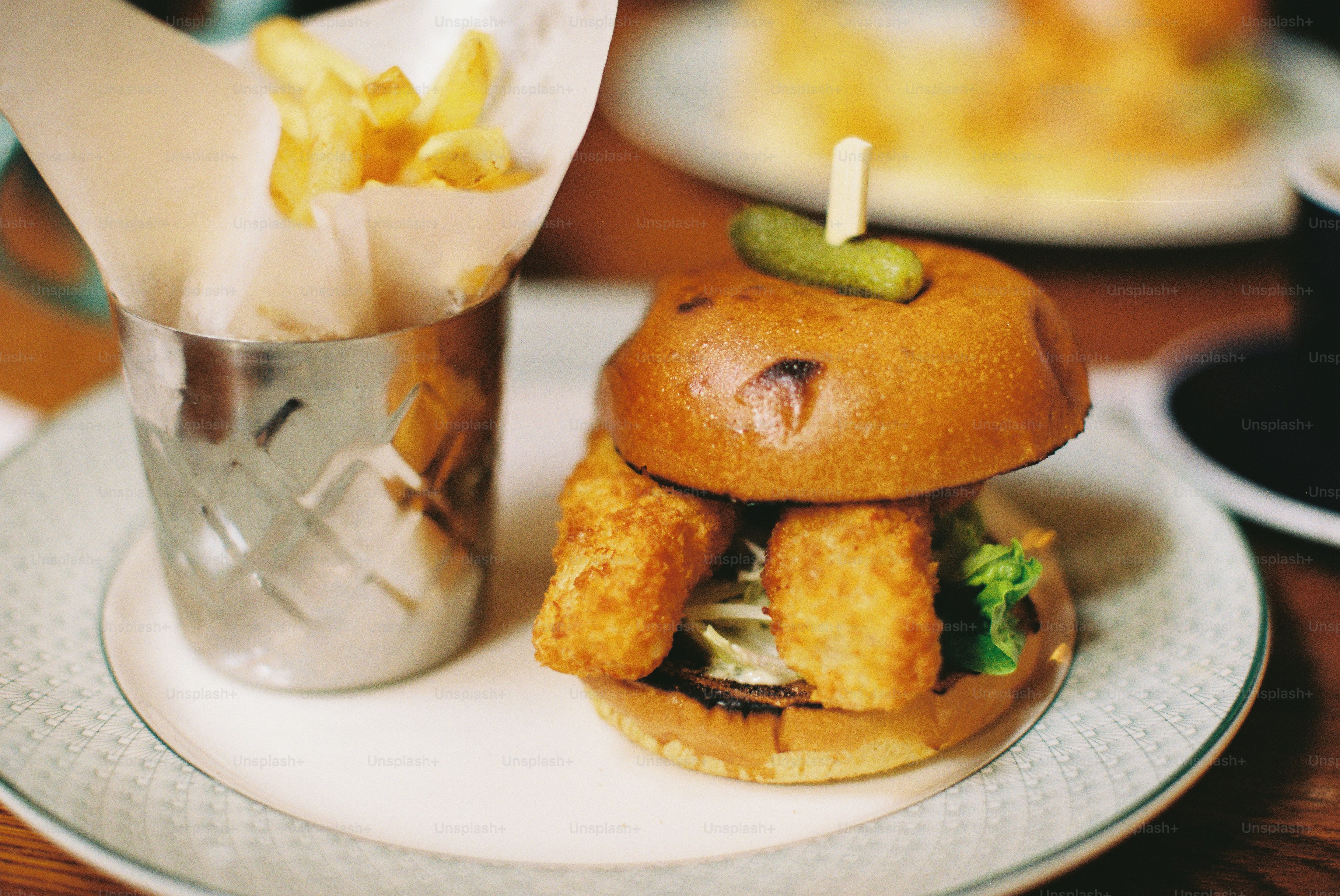 Un burger gourmet con pesce croccante e patatine fritte