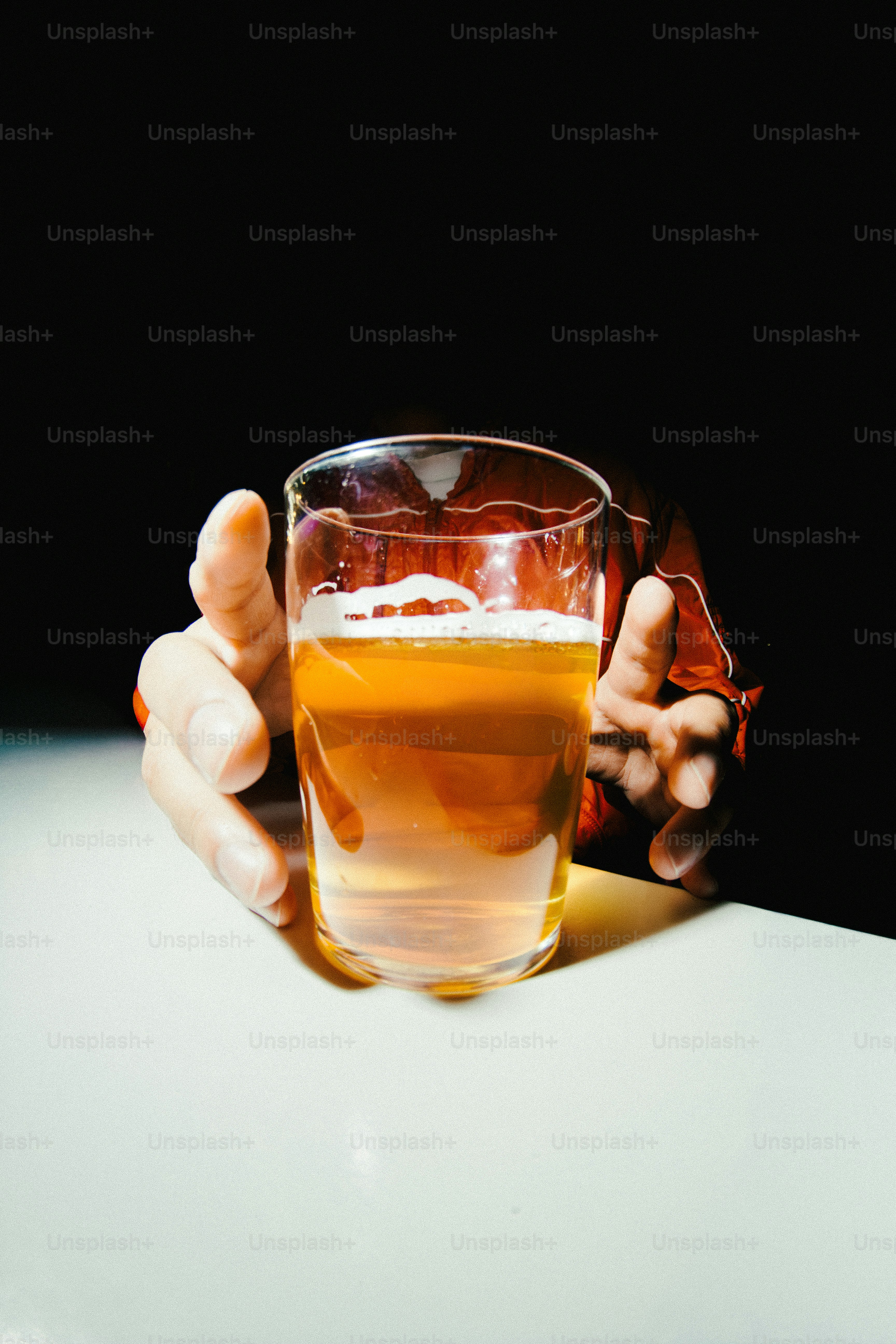 Una mano che cerca un bicchiere di birra