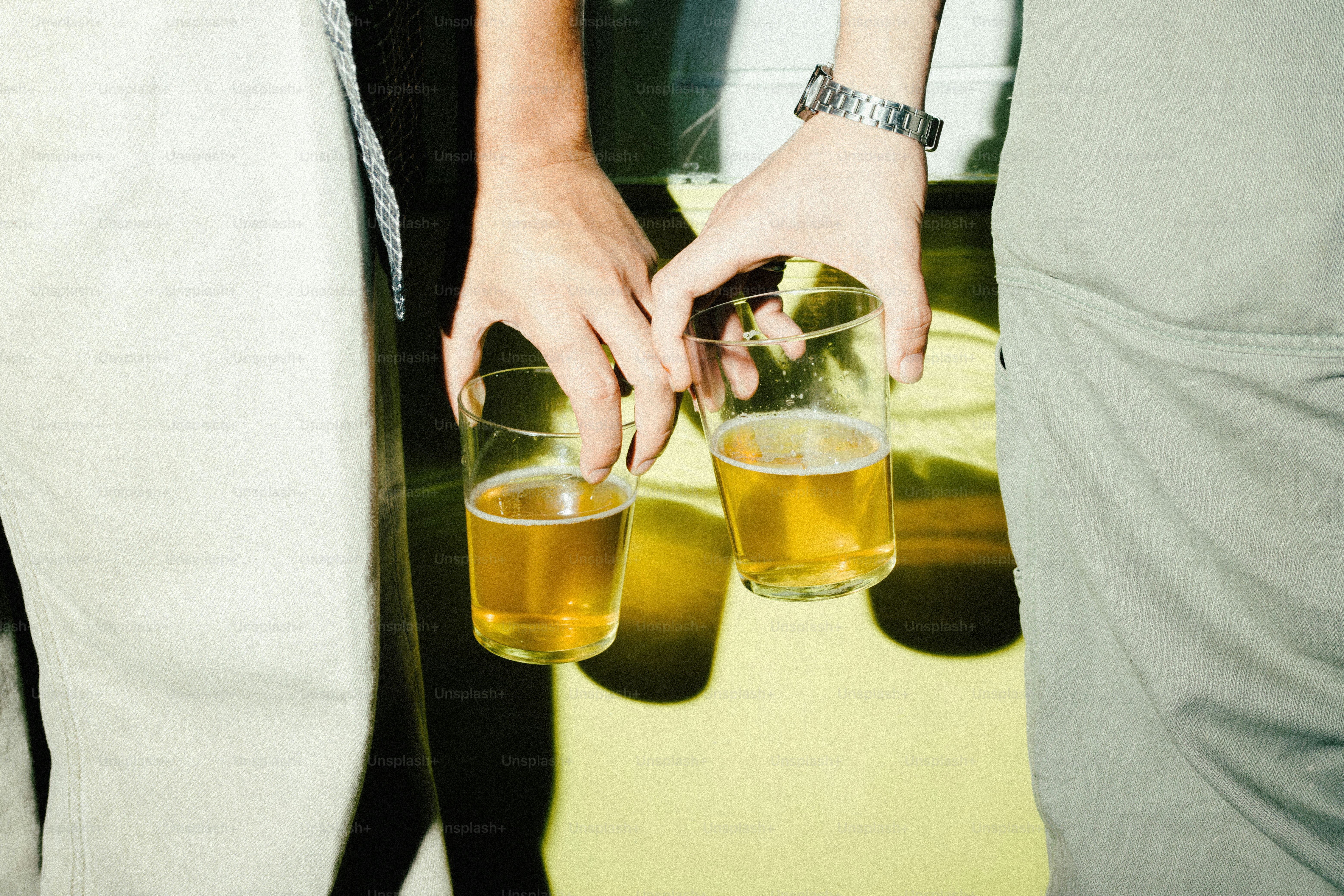 Due mani che tengono bicchieri di birra