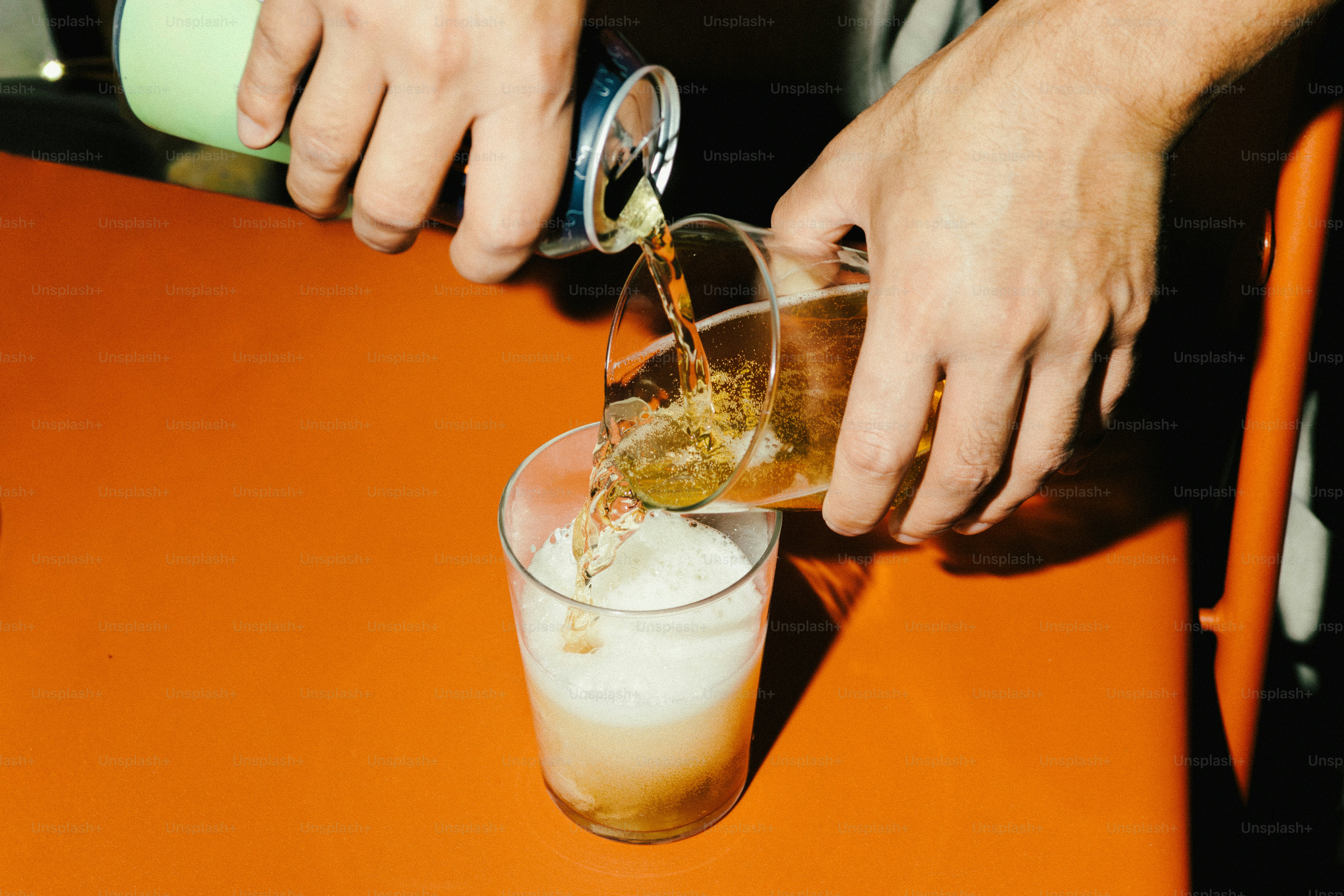 Mani che versano una bevanda dalla lattina in un bicchiere