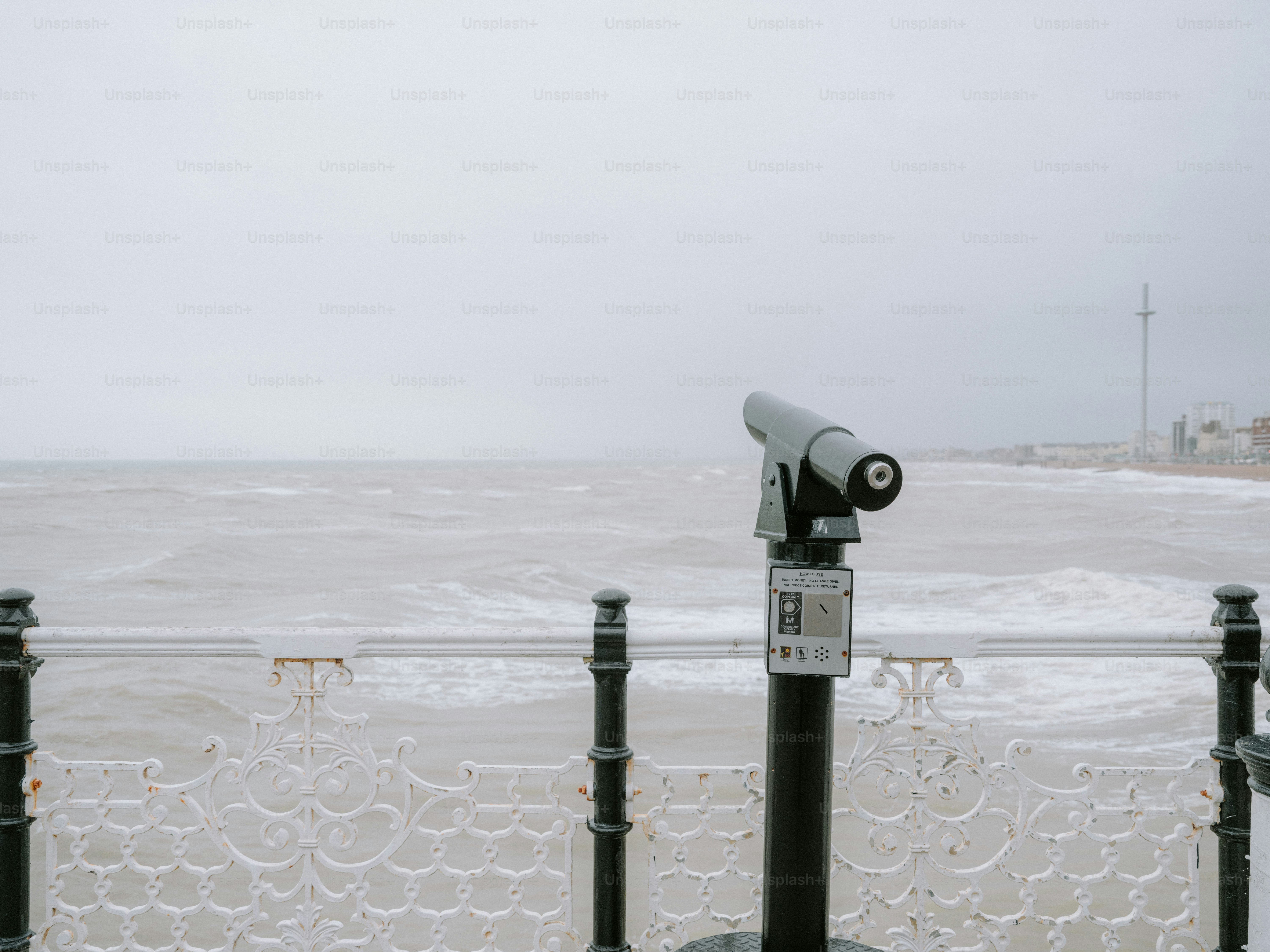 Telescopio en un muelle con vistas a un océano agitado