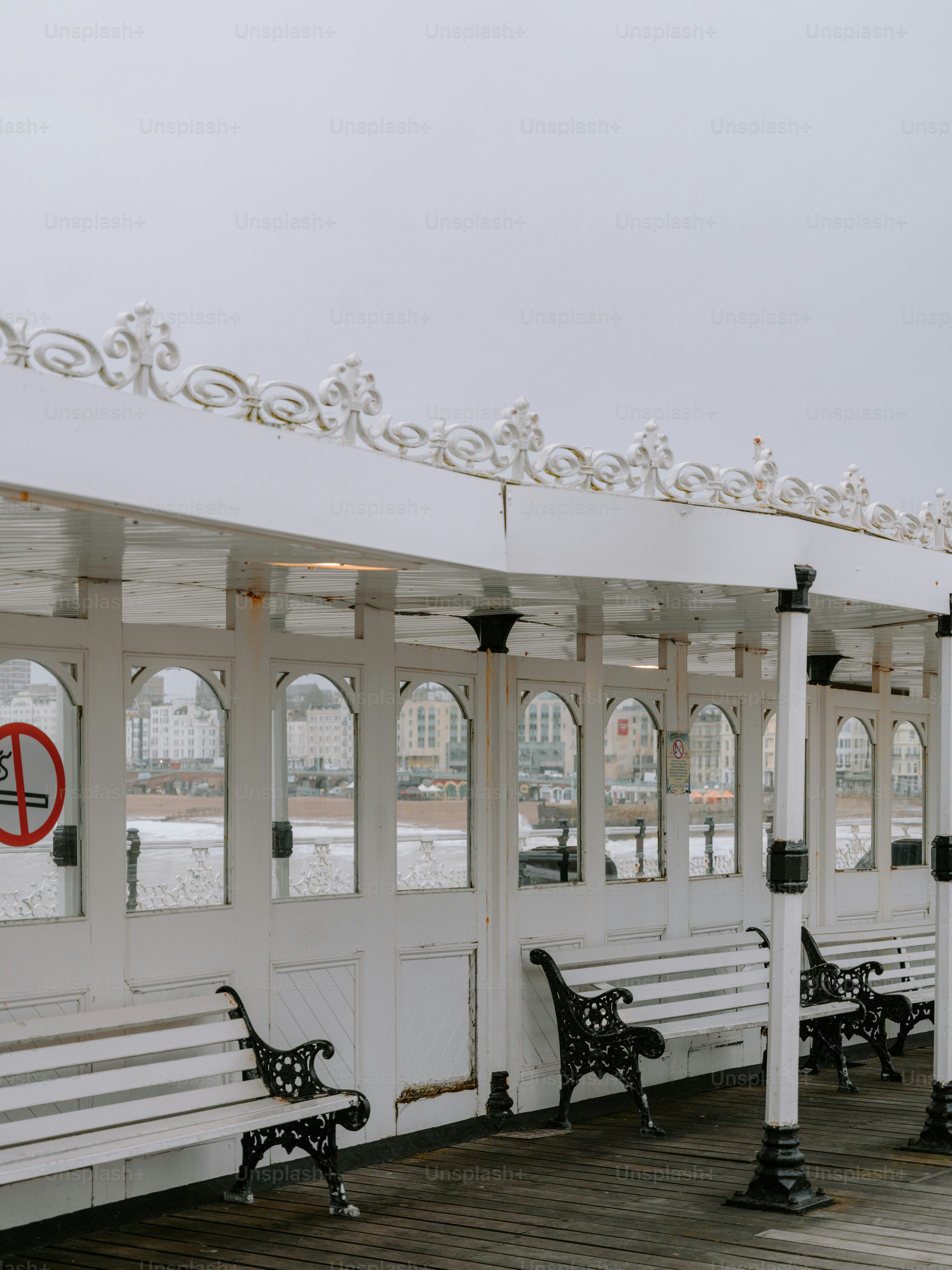 Bancos blancos bajo un toldo decorativo en un pilar