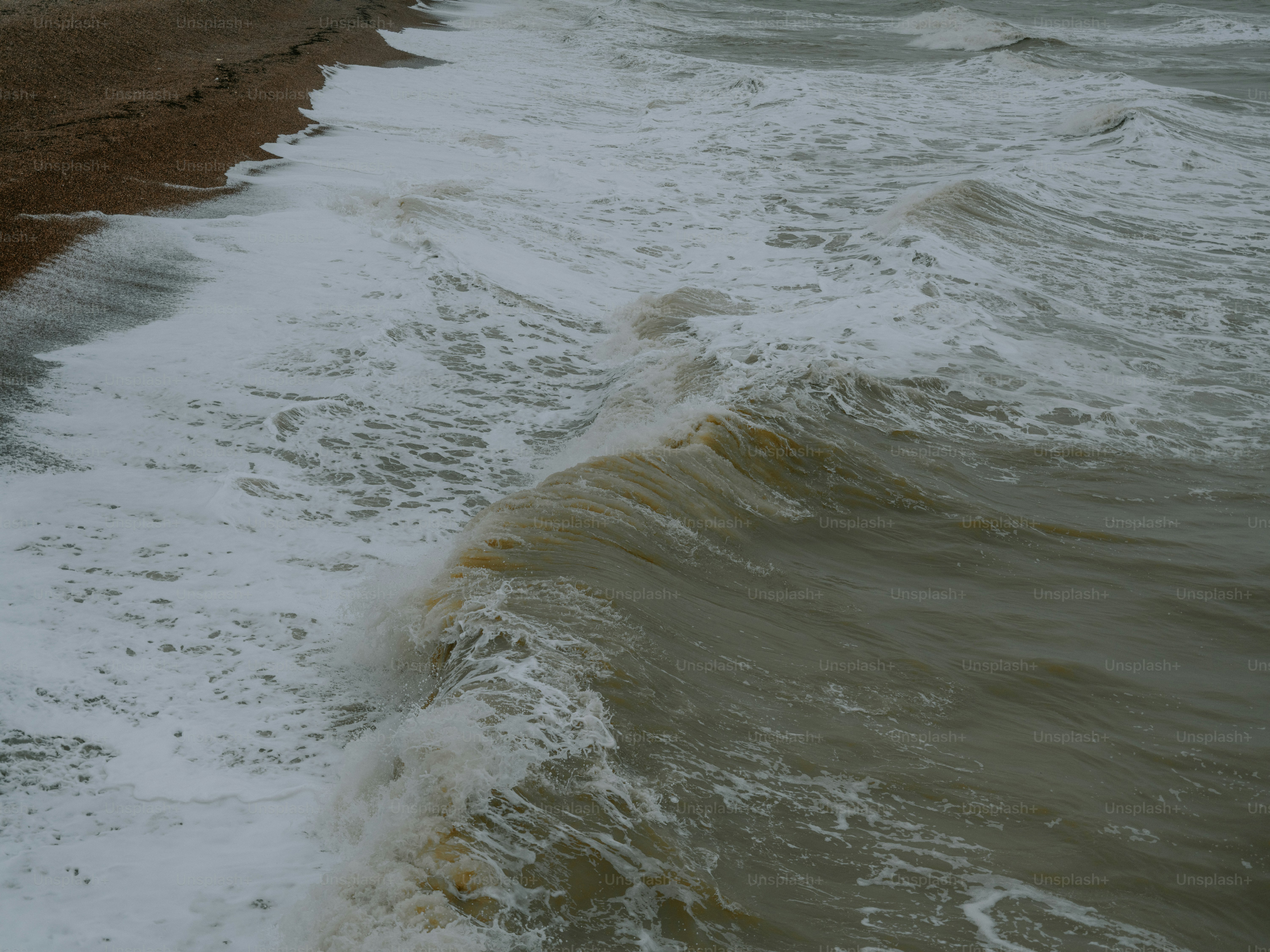 Ombak kasar menghantam pantai kerikil