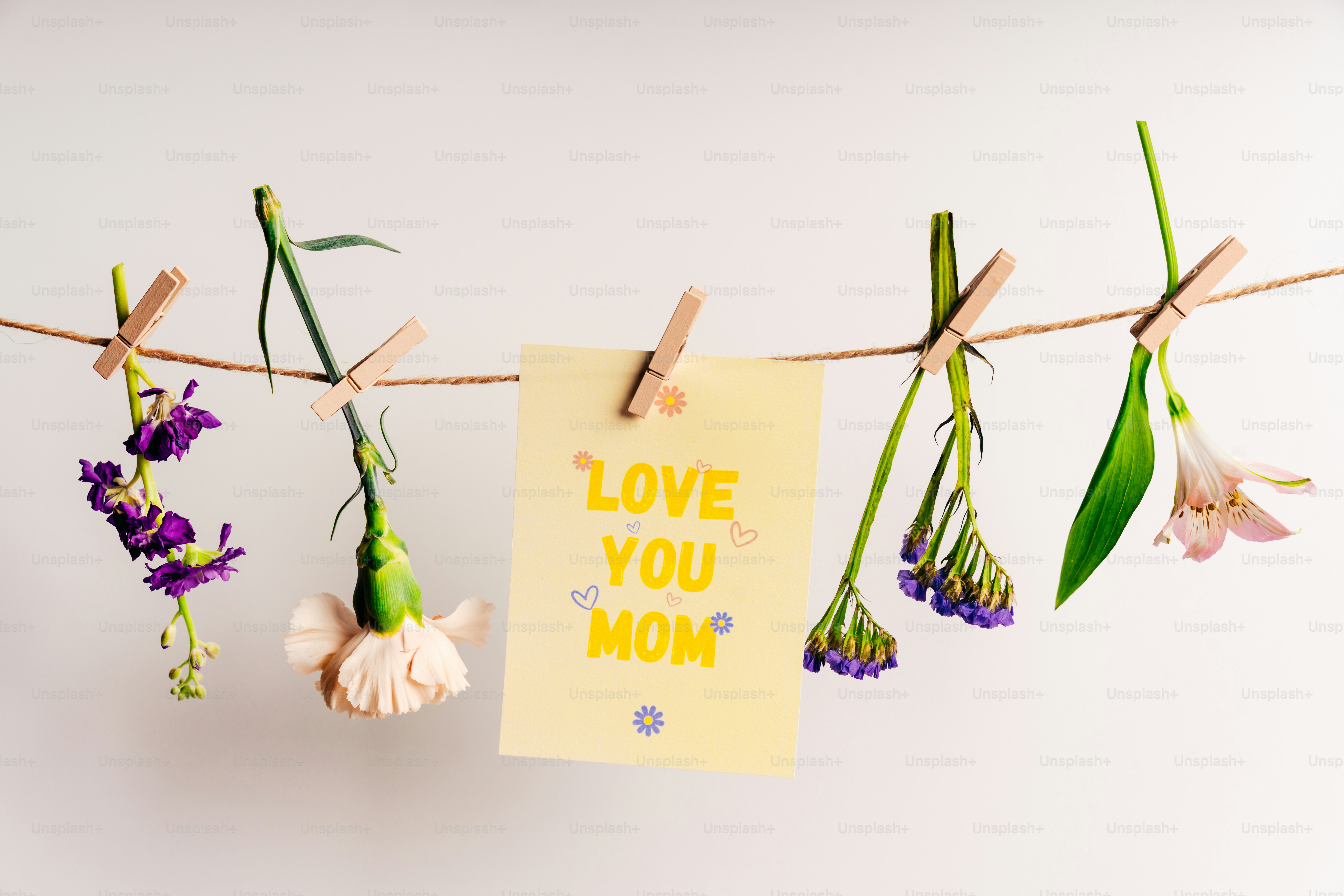 Flowers and card saying "love you mom" on a line