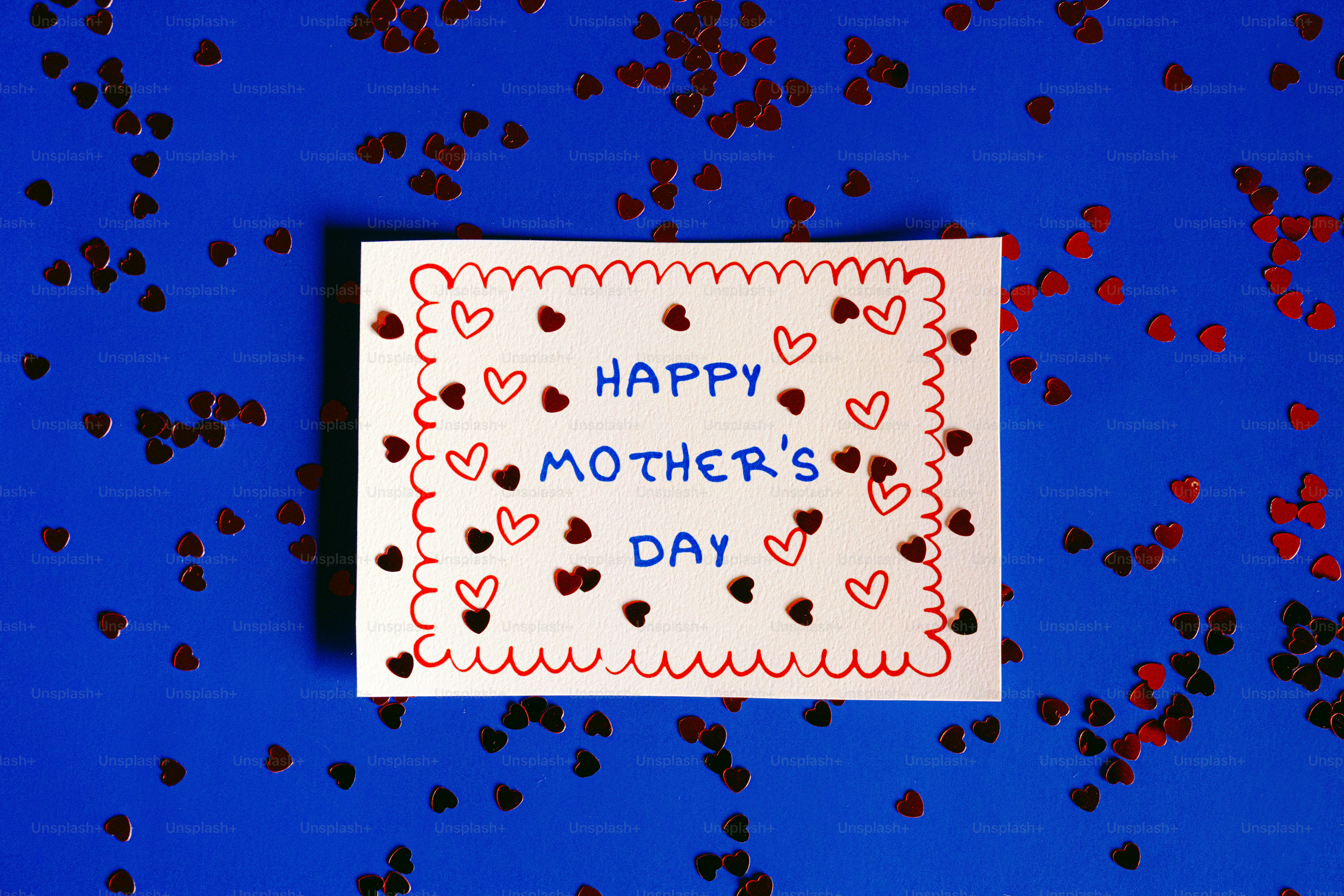 Happy mother's day card surrounded by heart confetti.