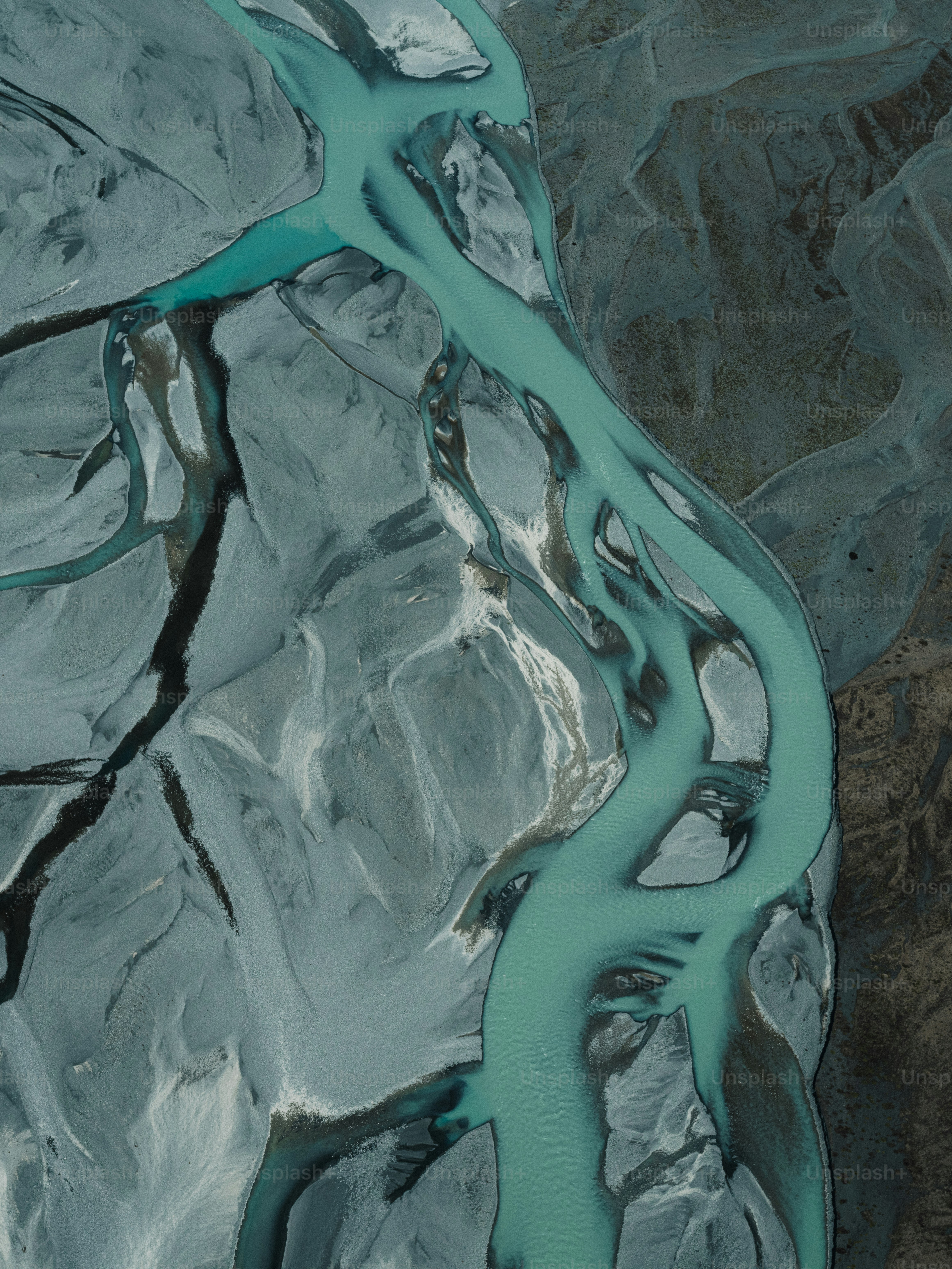 Vista aérea de un río turquesa que serpentea por un terreno rocoso