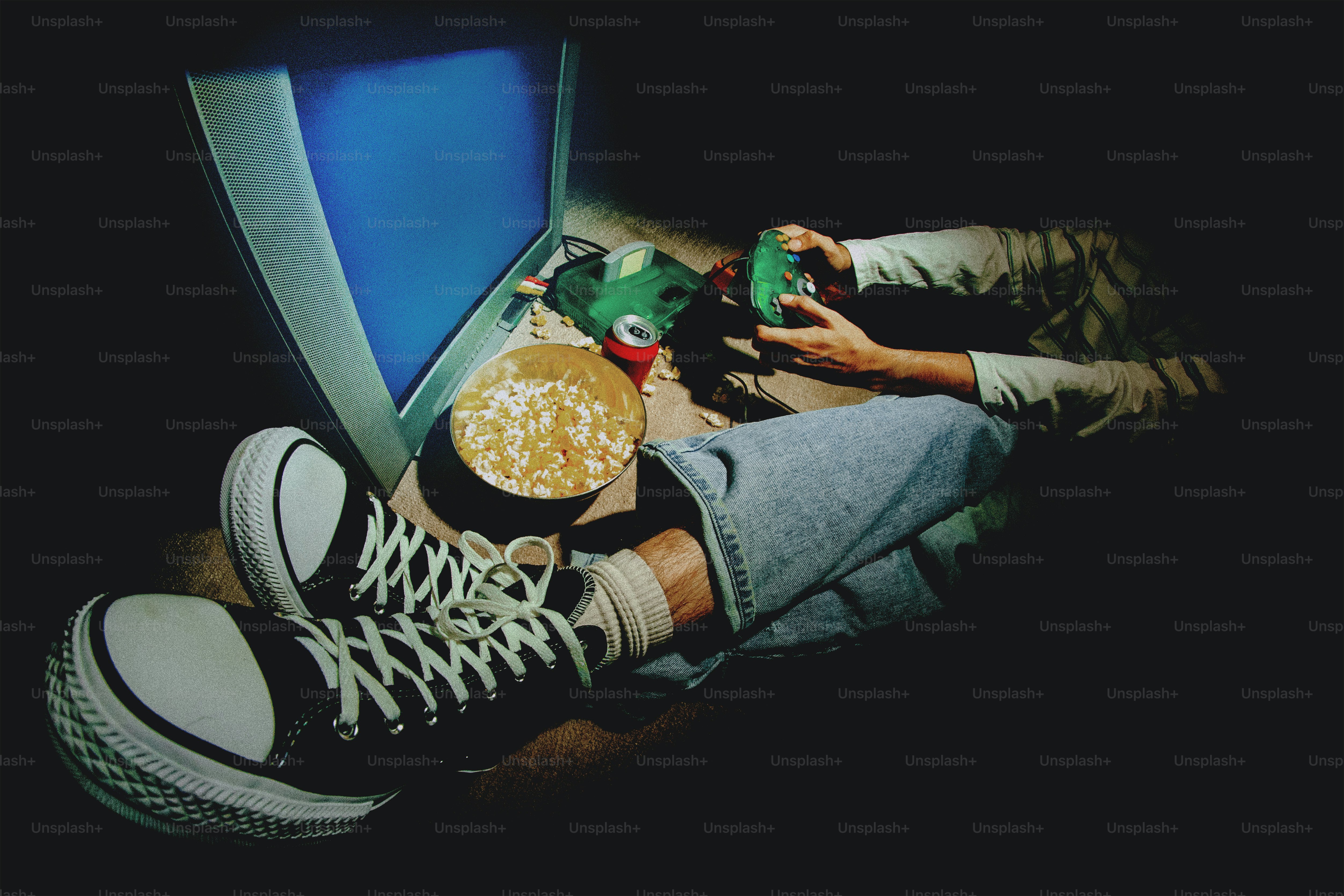 Persona viendo la televisión con palomitas y mando.