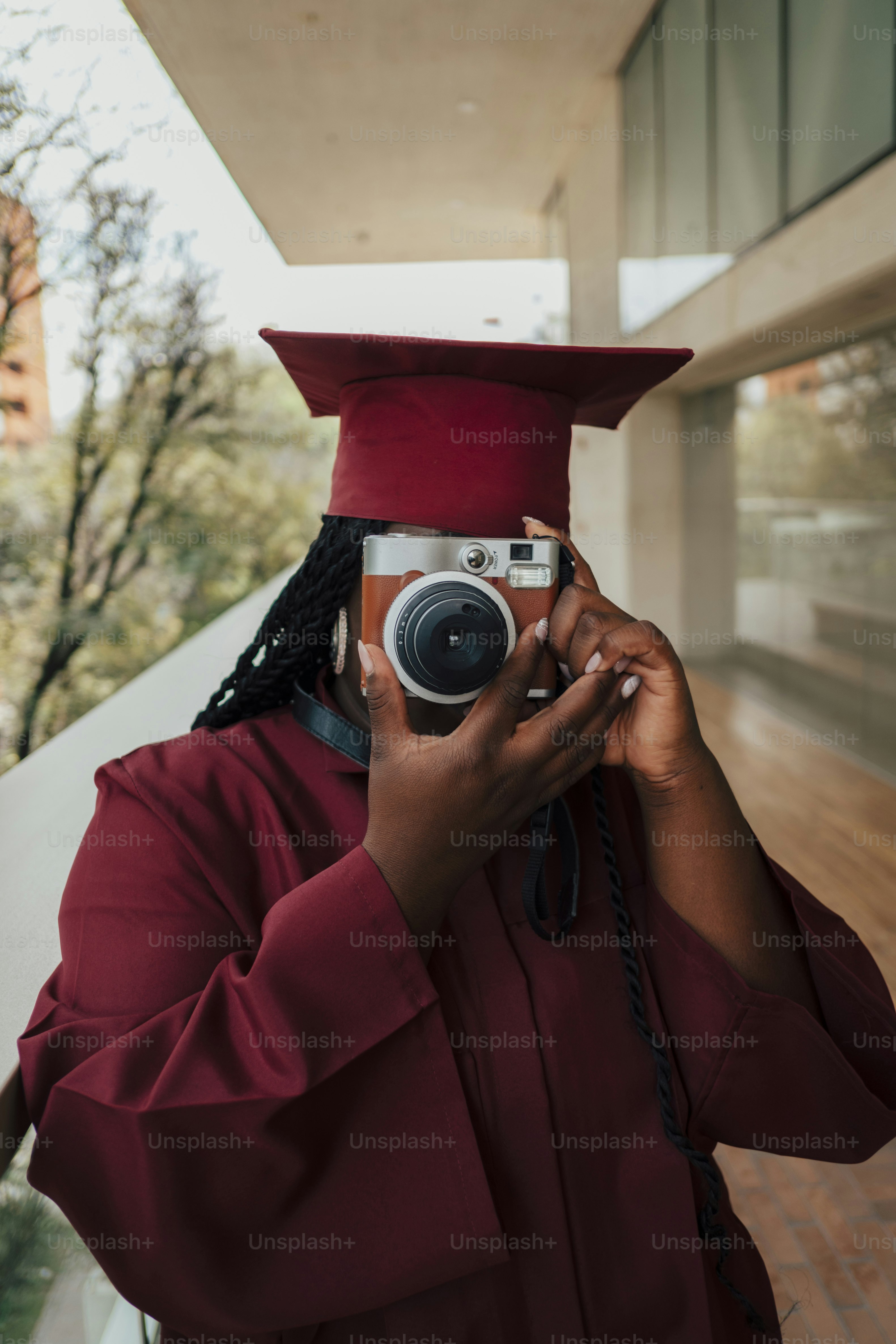 Graduate in cap and gown holds camera to face. photo – Education Image ...