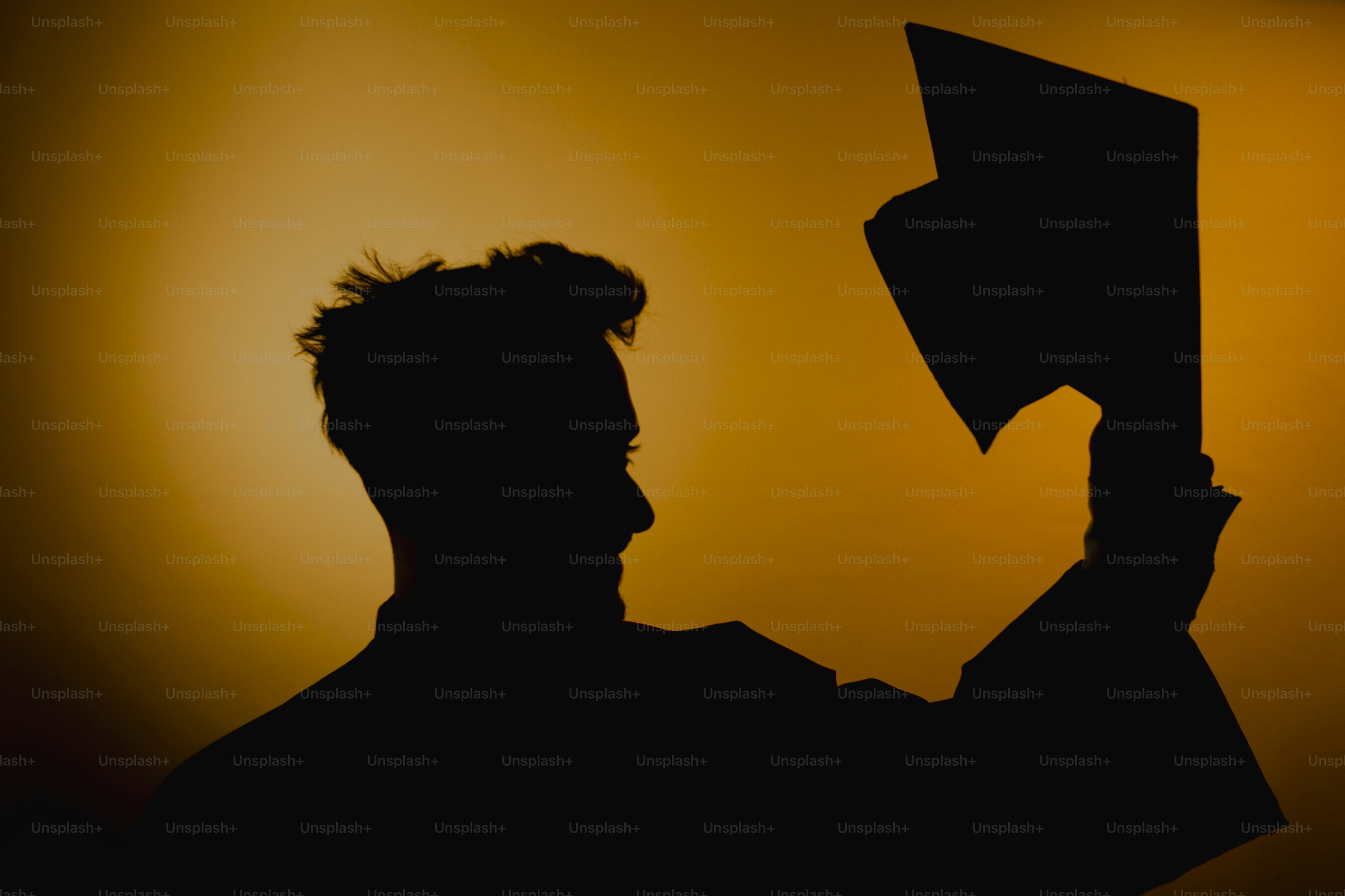 Silhouette of a person holding up a diploma