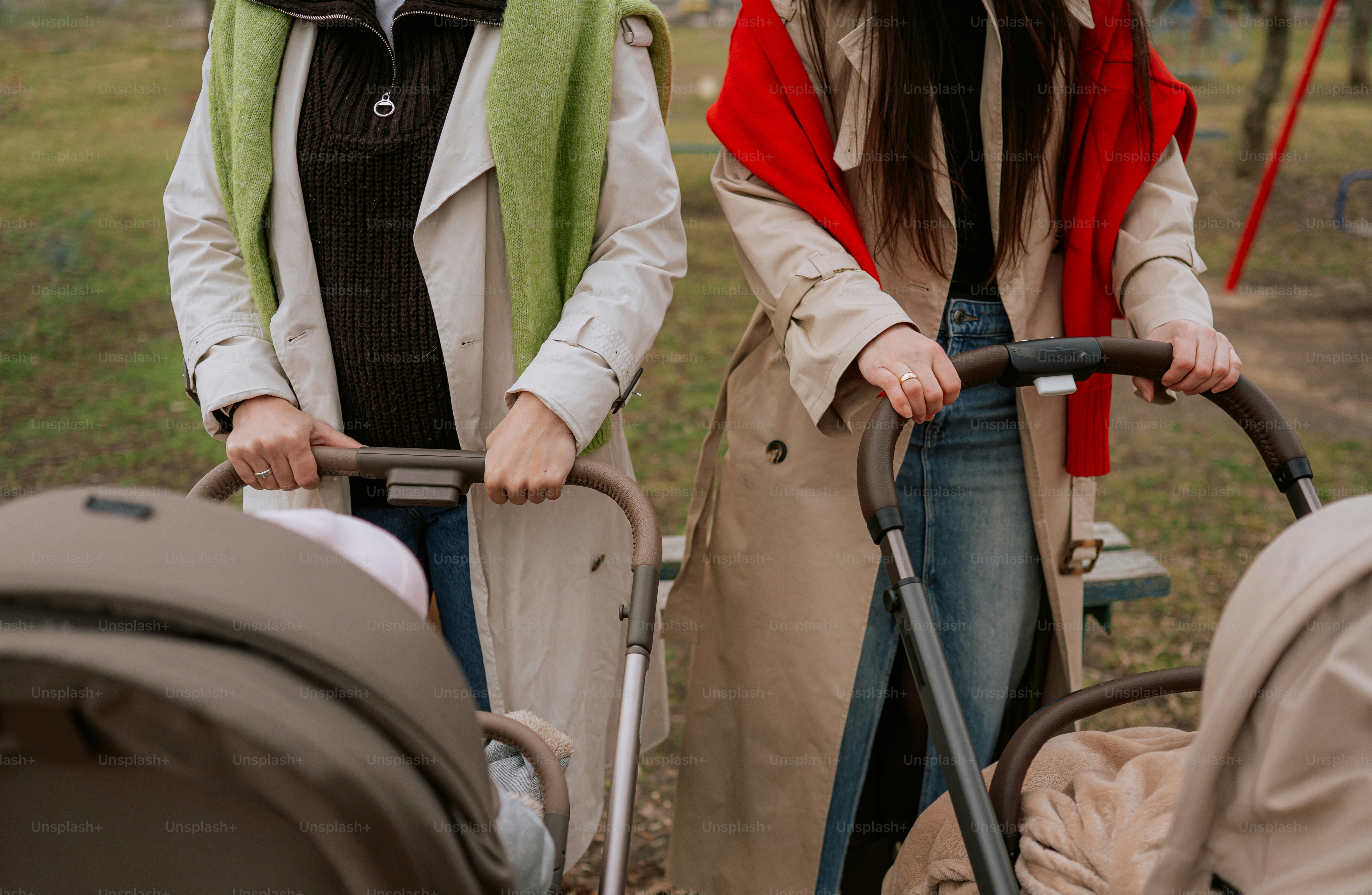 Two women pushing strollers outdoors