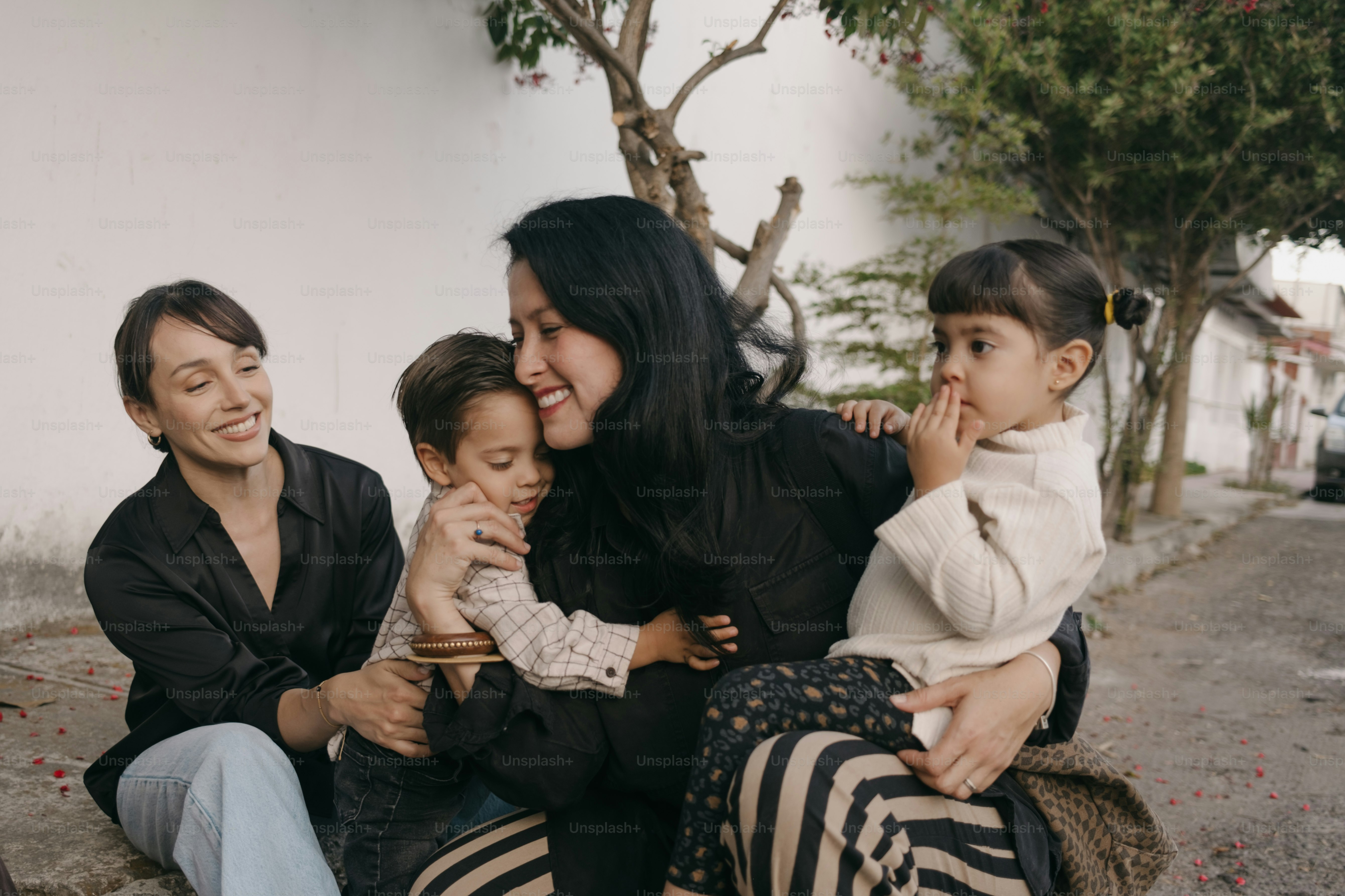 Deux femmes et deux enfants s’embrassant en plein air