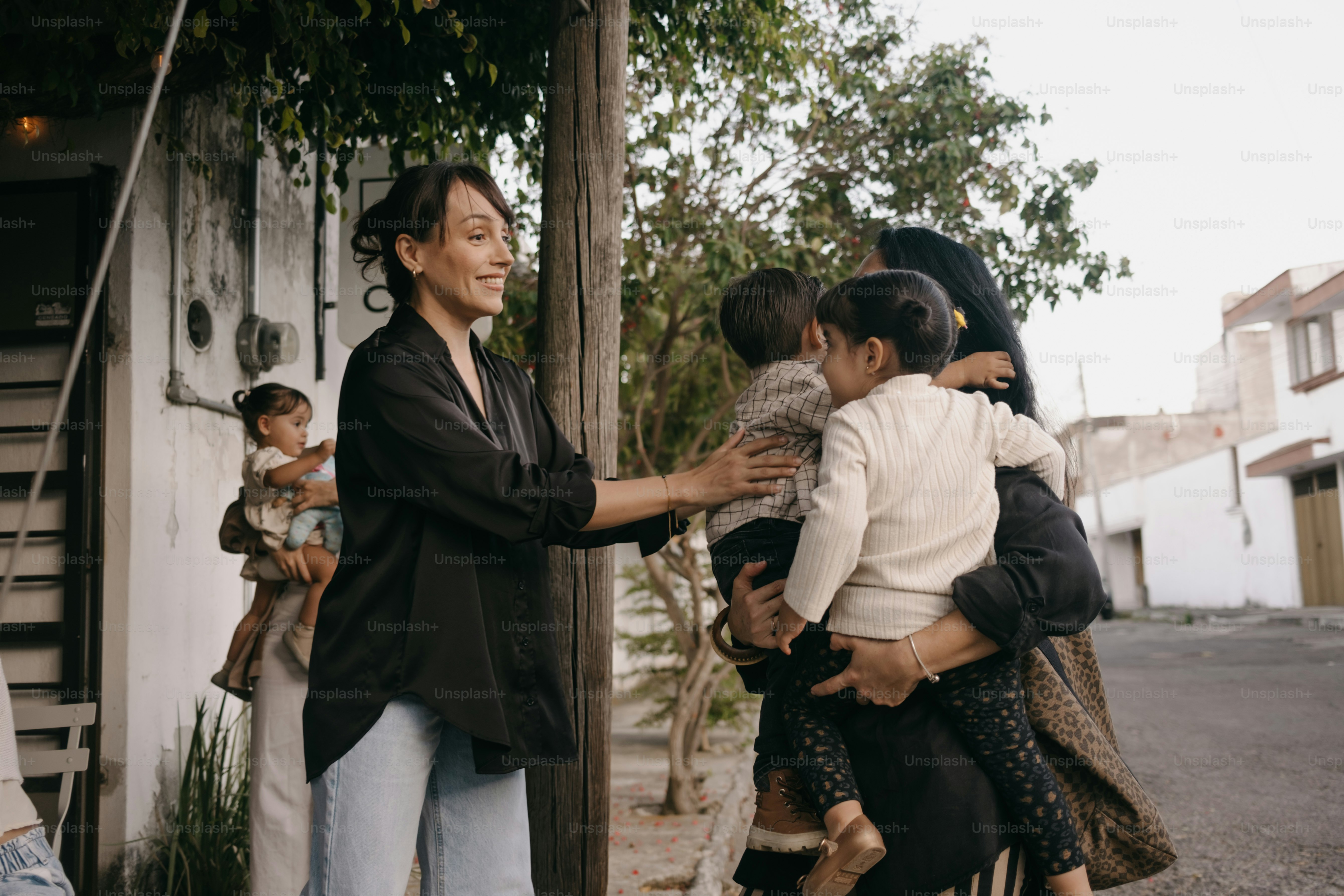 Une femme accueille la famille avec des enfants dehors enfants