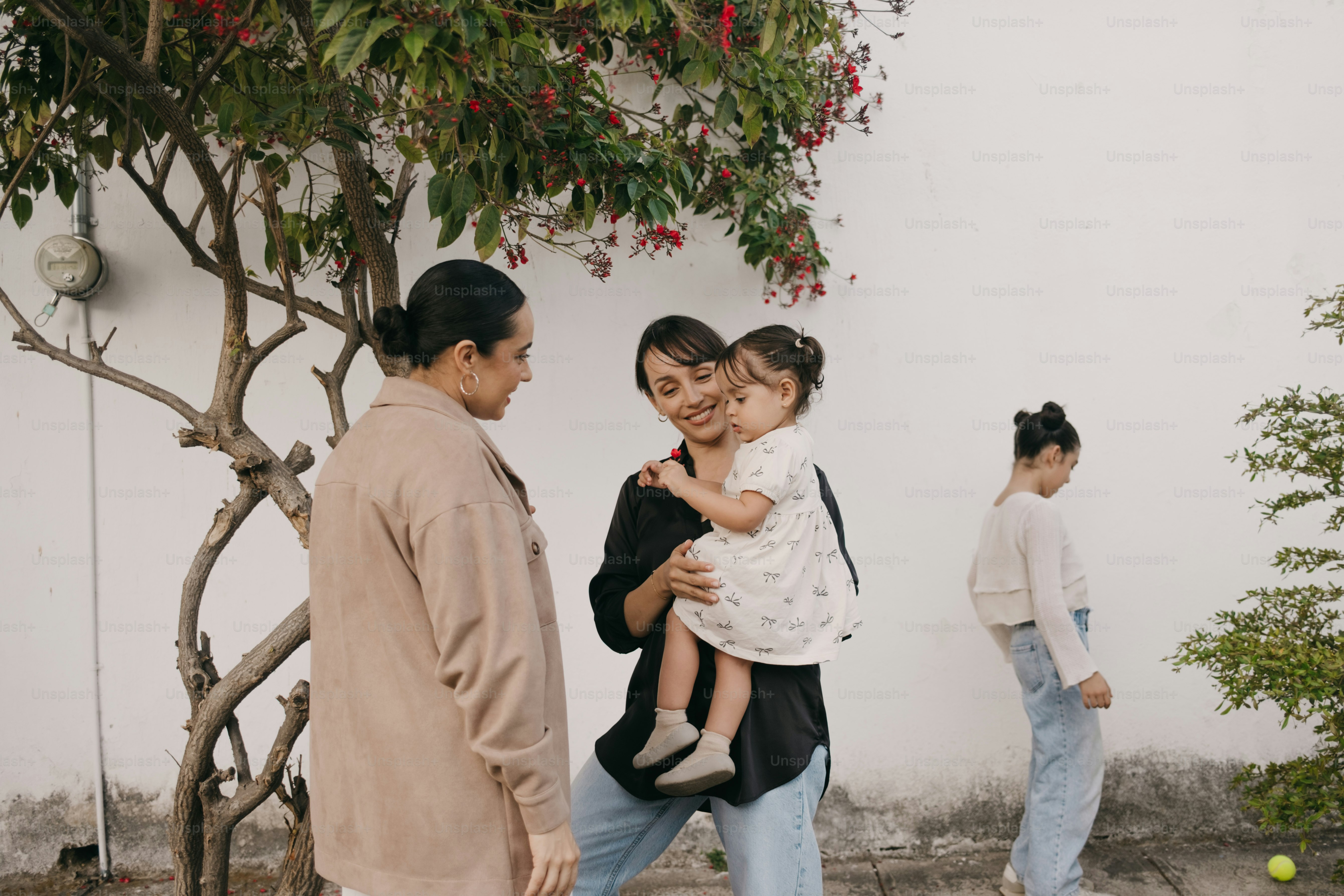 Trois femmes et un jeune enfant dans un jardin