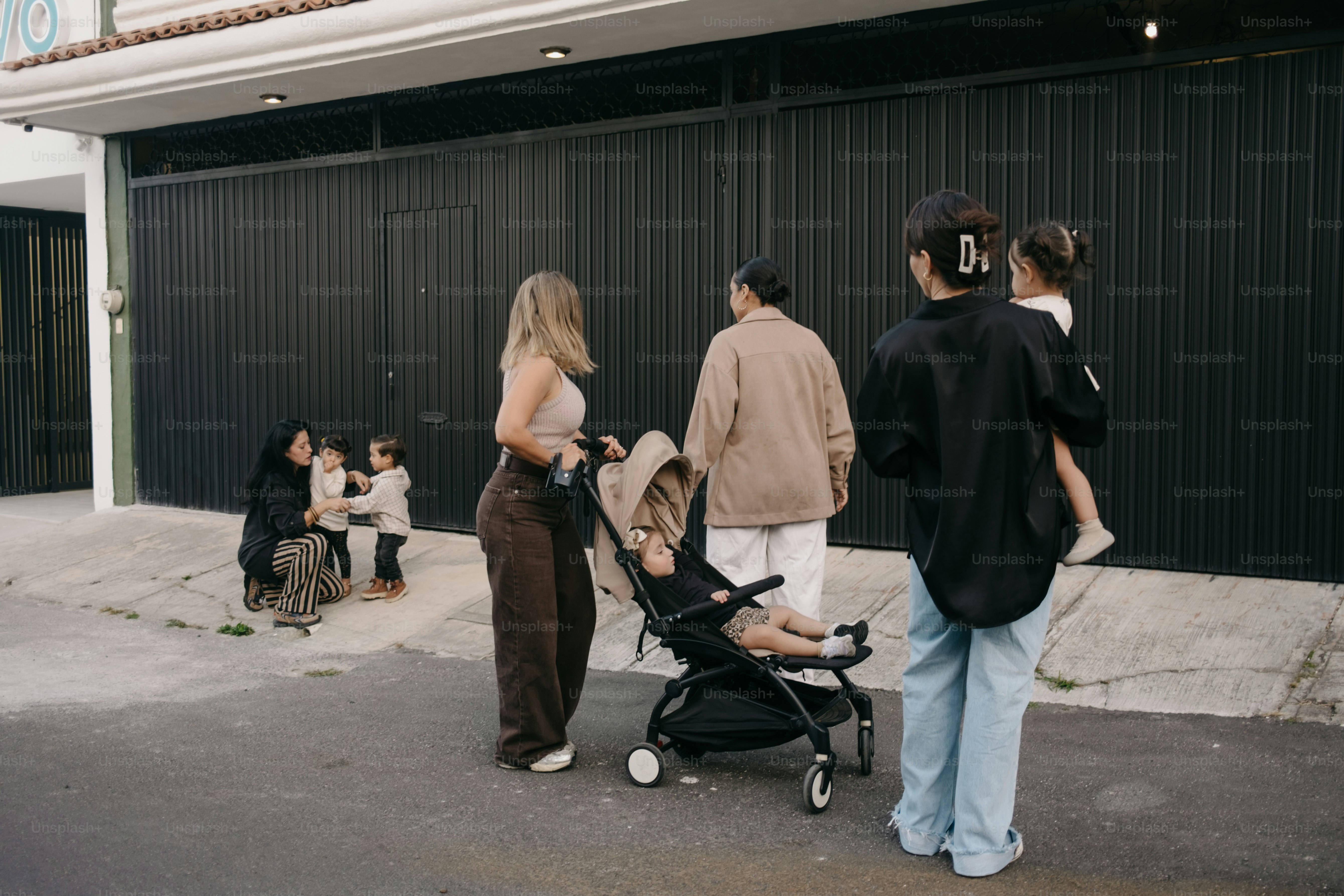 Des gens debout dans la rue avec une poussette.