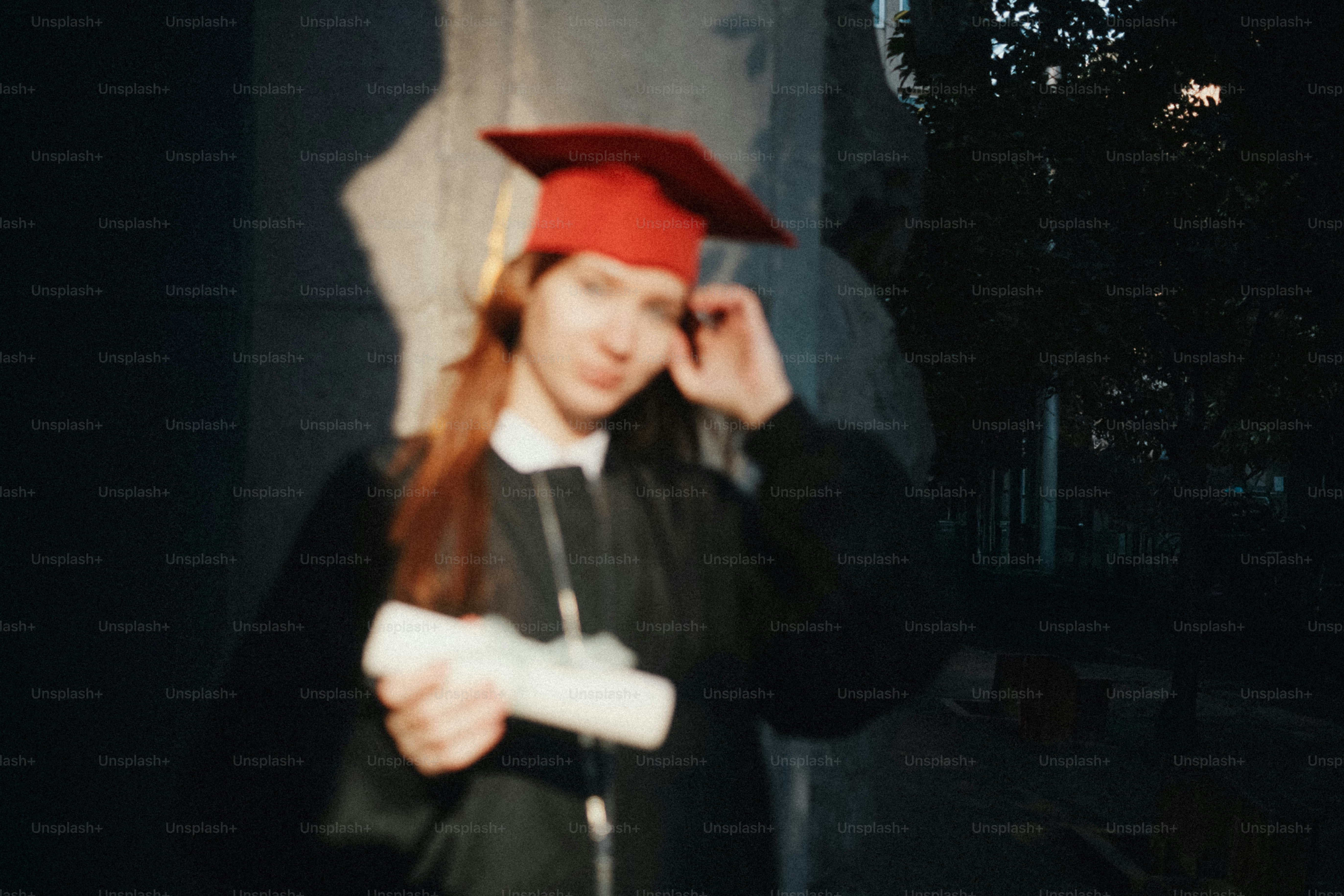 Young woman in graduation cap and gown holding diploma photo ...