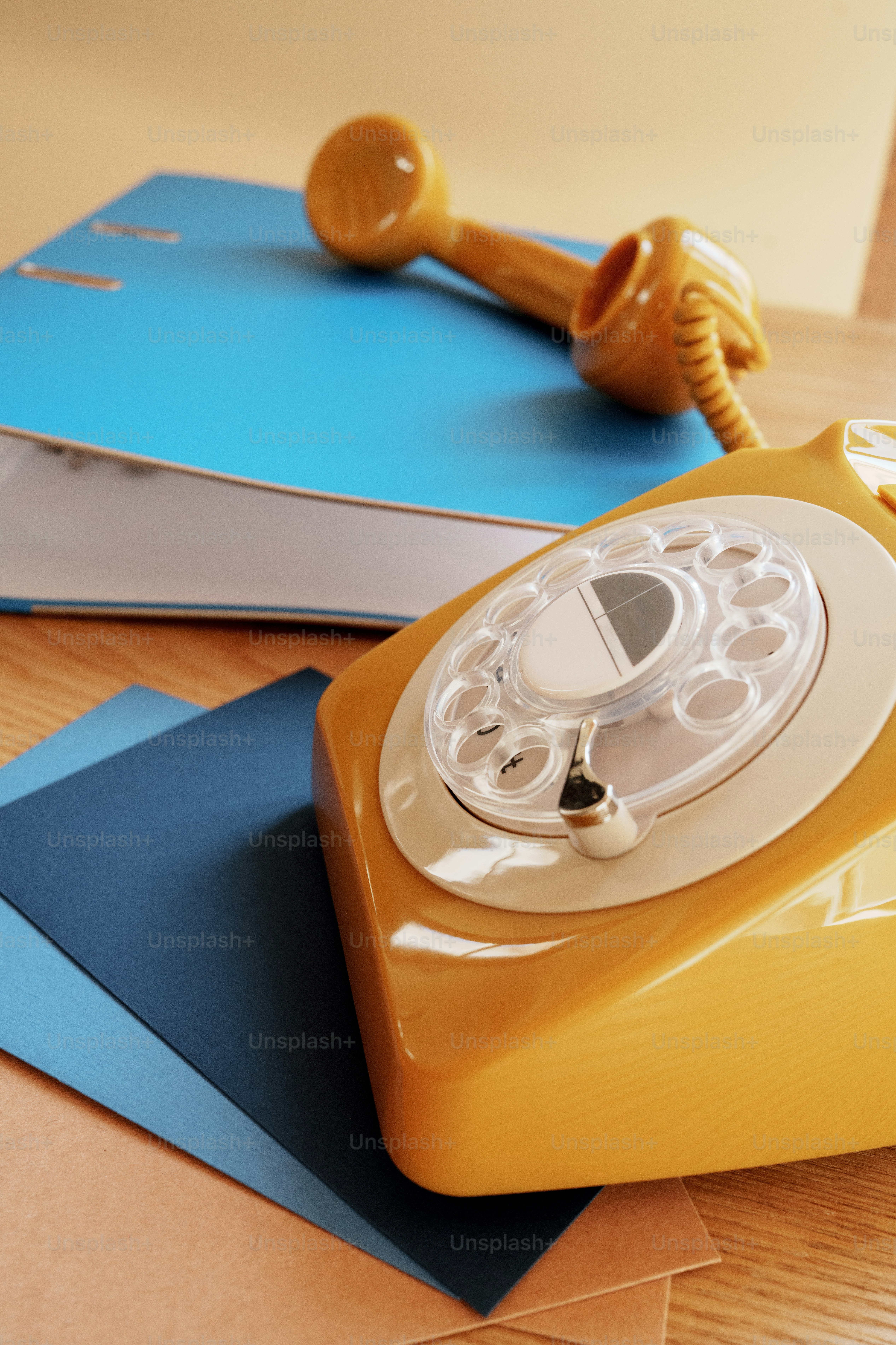A vintage rotary phone rests on office supplies.