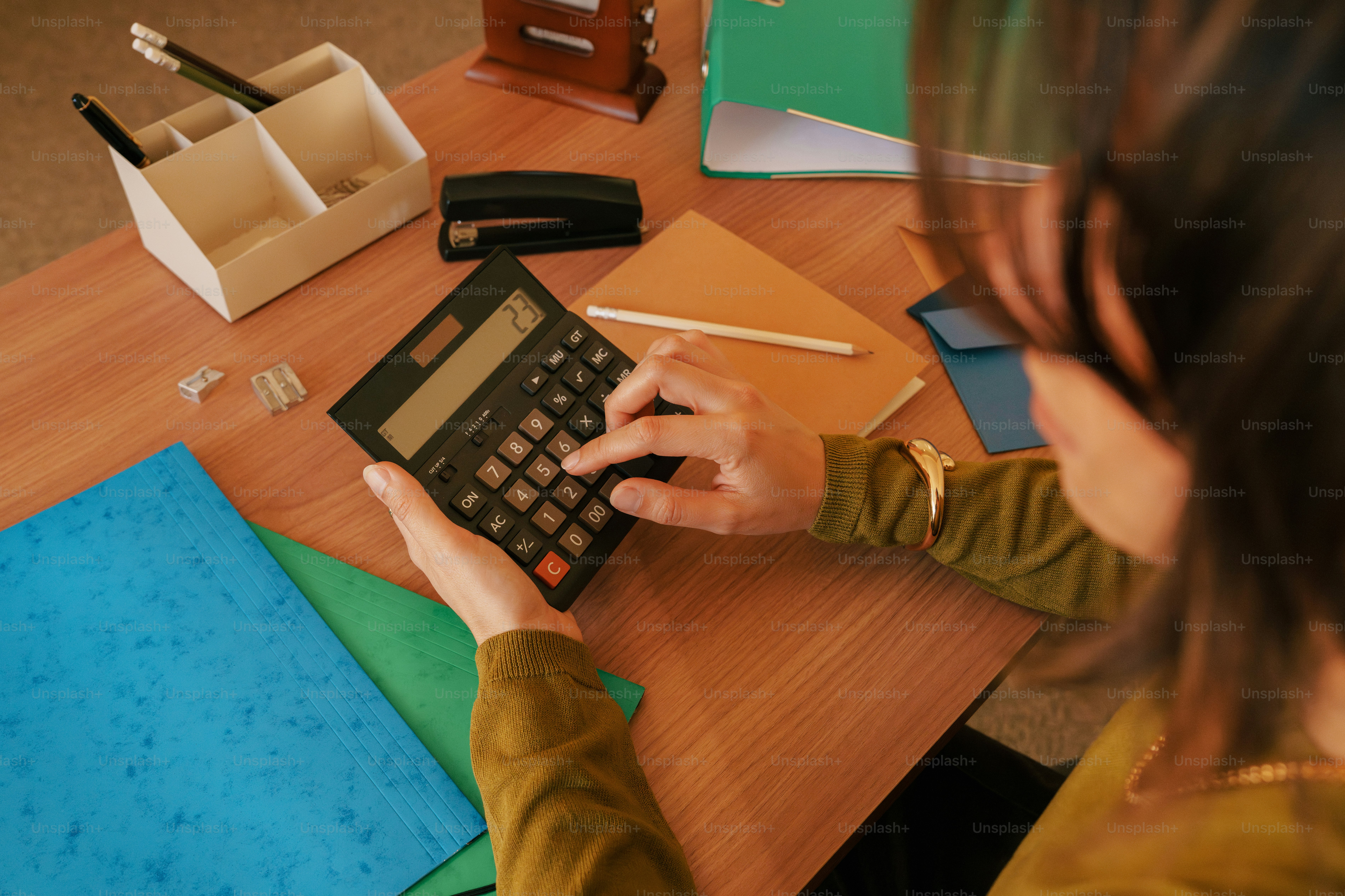 Woman using calculator at a cluttered desk photo – Business Image on ...