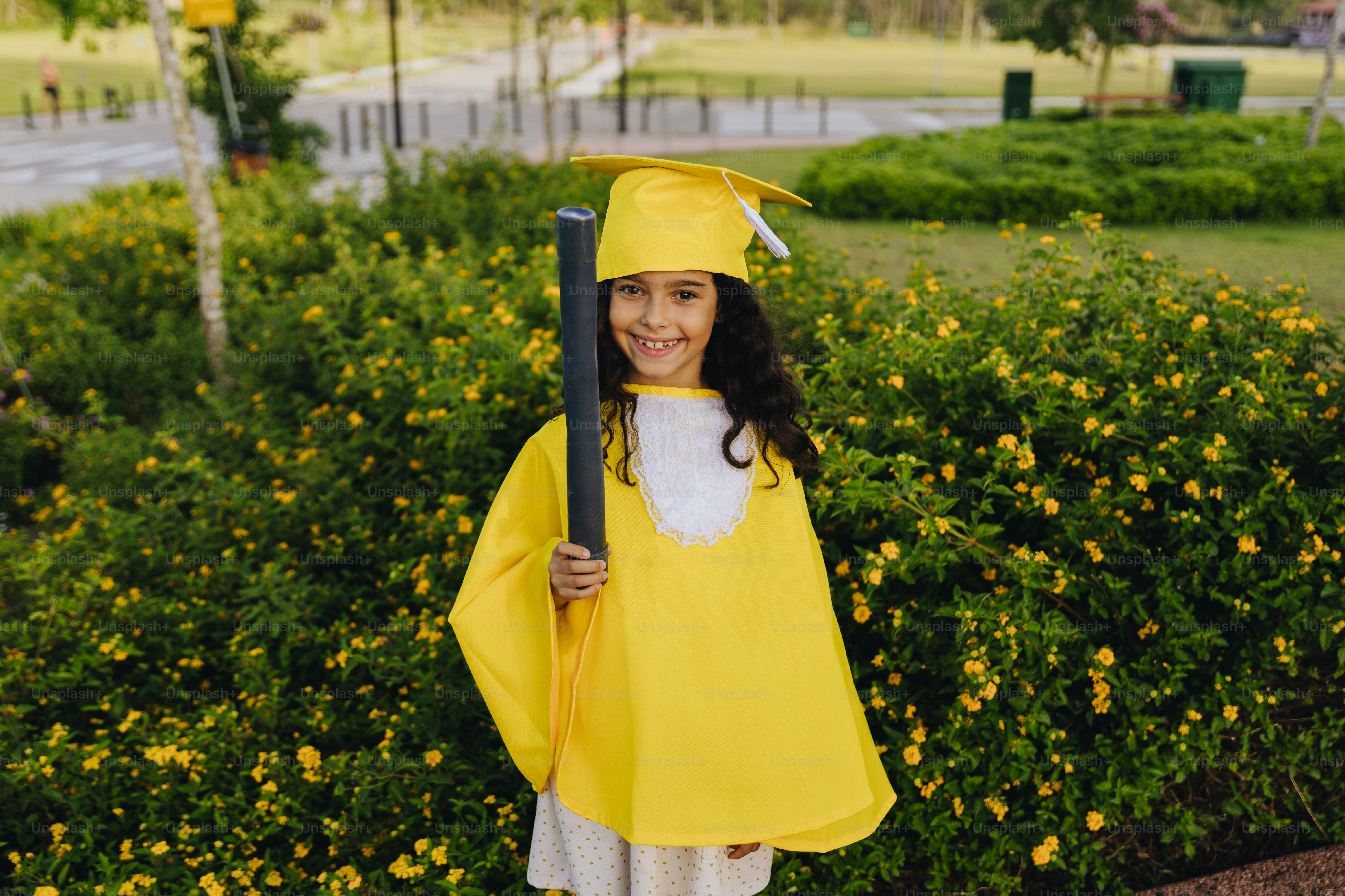 Young girl in yellow graduation cap and gown photo – Education Image on ...