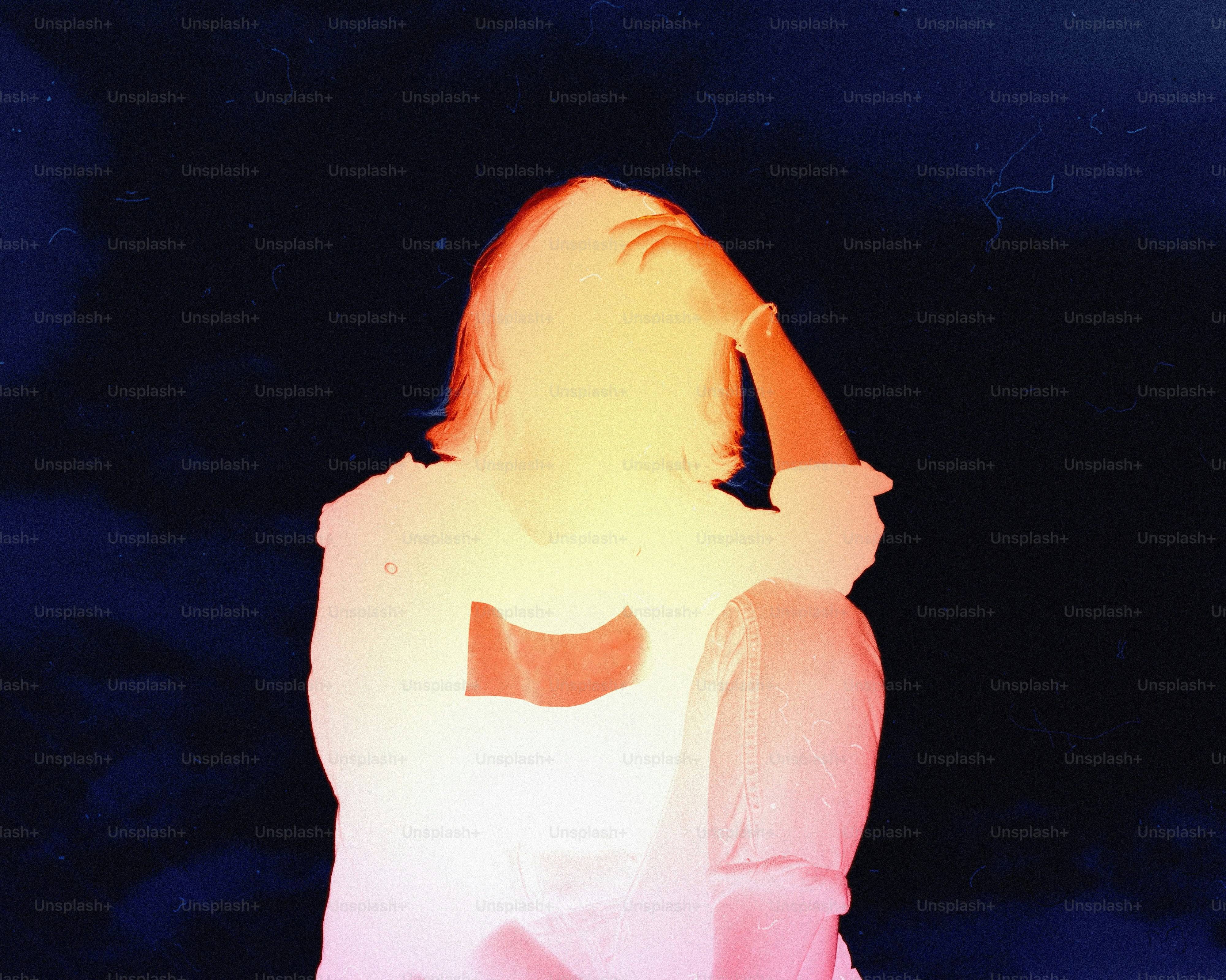 Woman with hand in hair against dark background