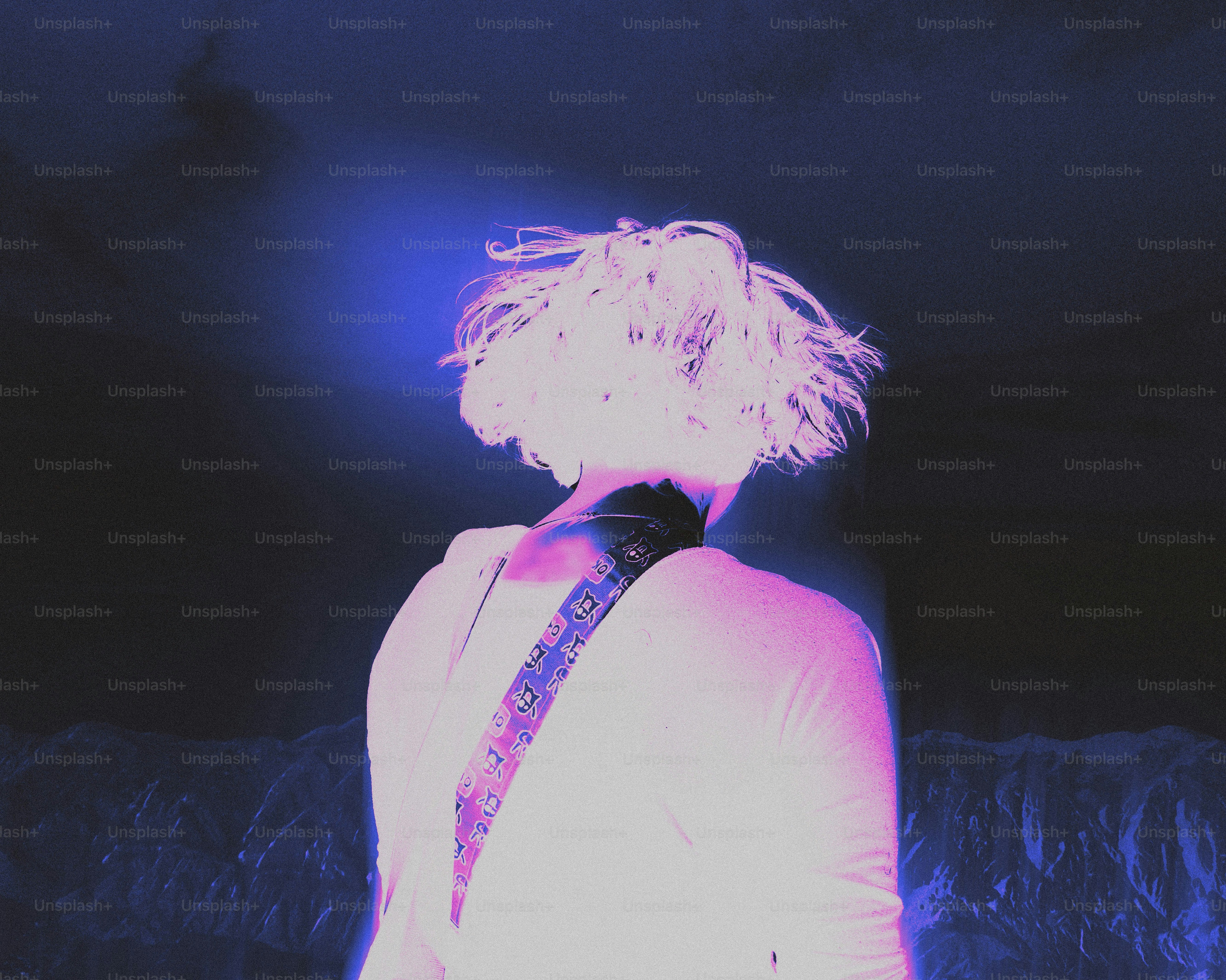 Person with white hair wearing a guitar strap
