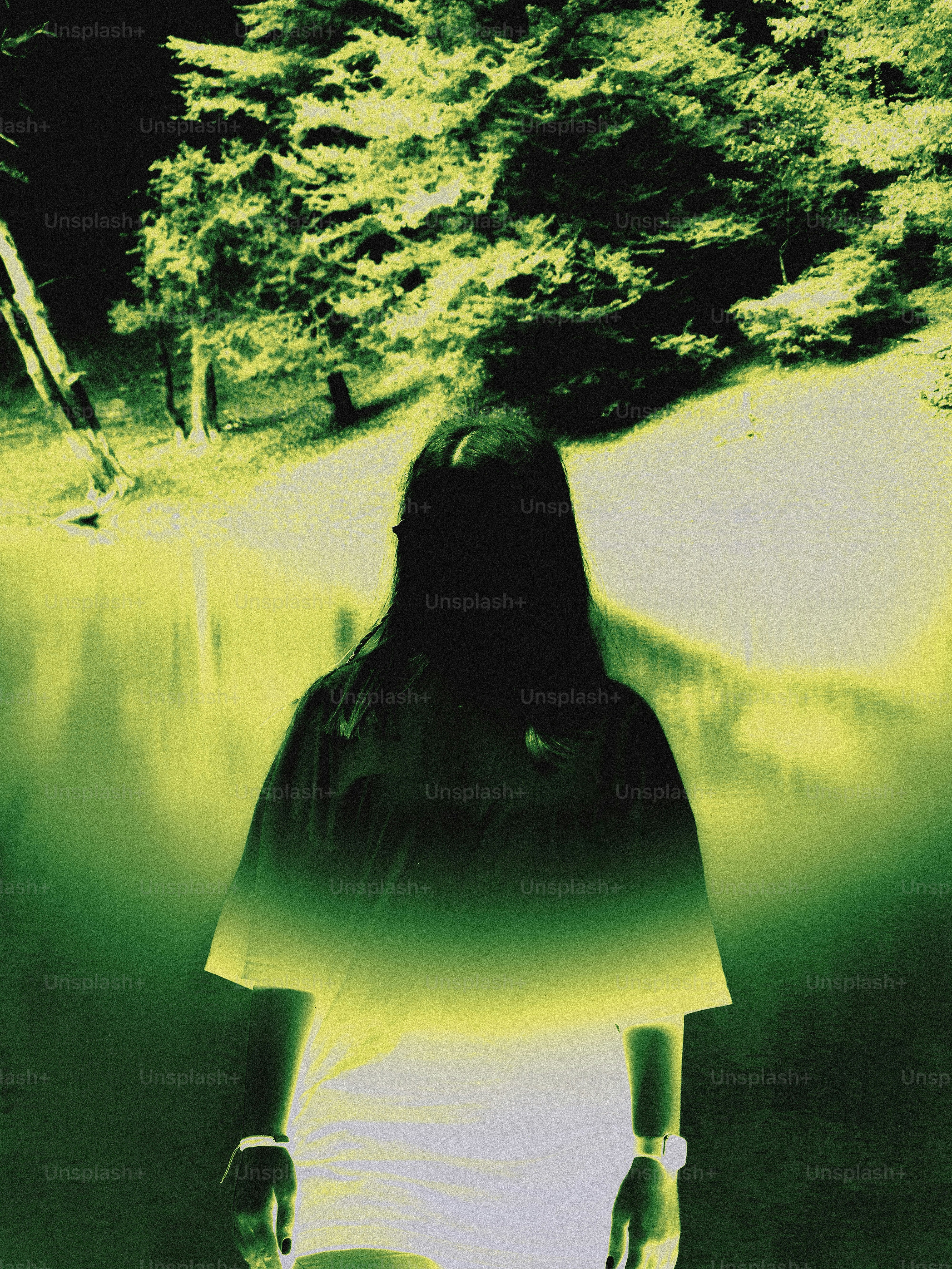 Woman standing by a lake with trees