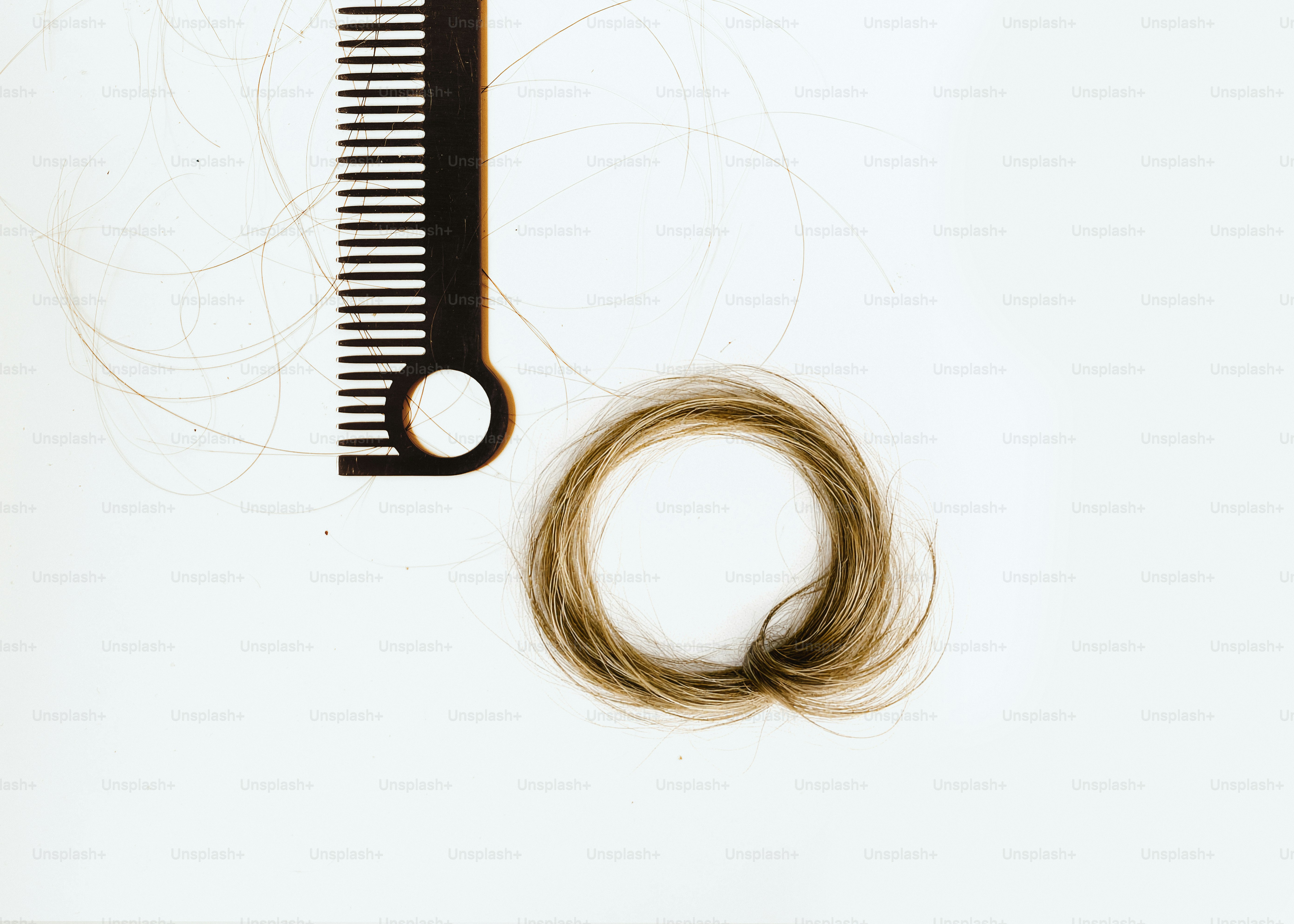 Ein Kamm und ein Haarbüschel auf weißem Hintergrund