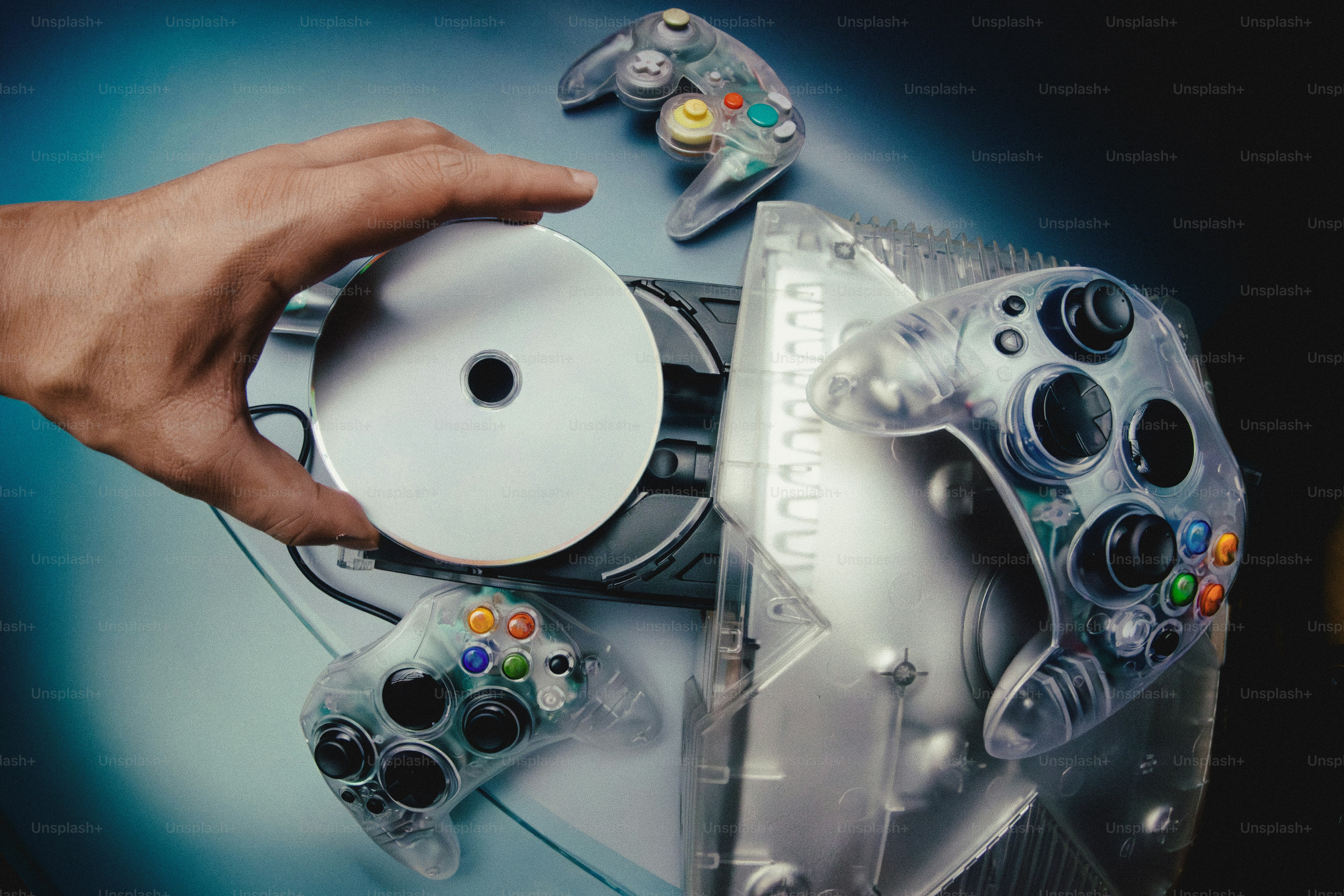 Tenir un CD dans la main au-dessus de consoles de jeux vidéo et de manettes