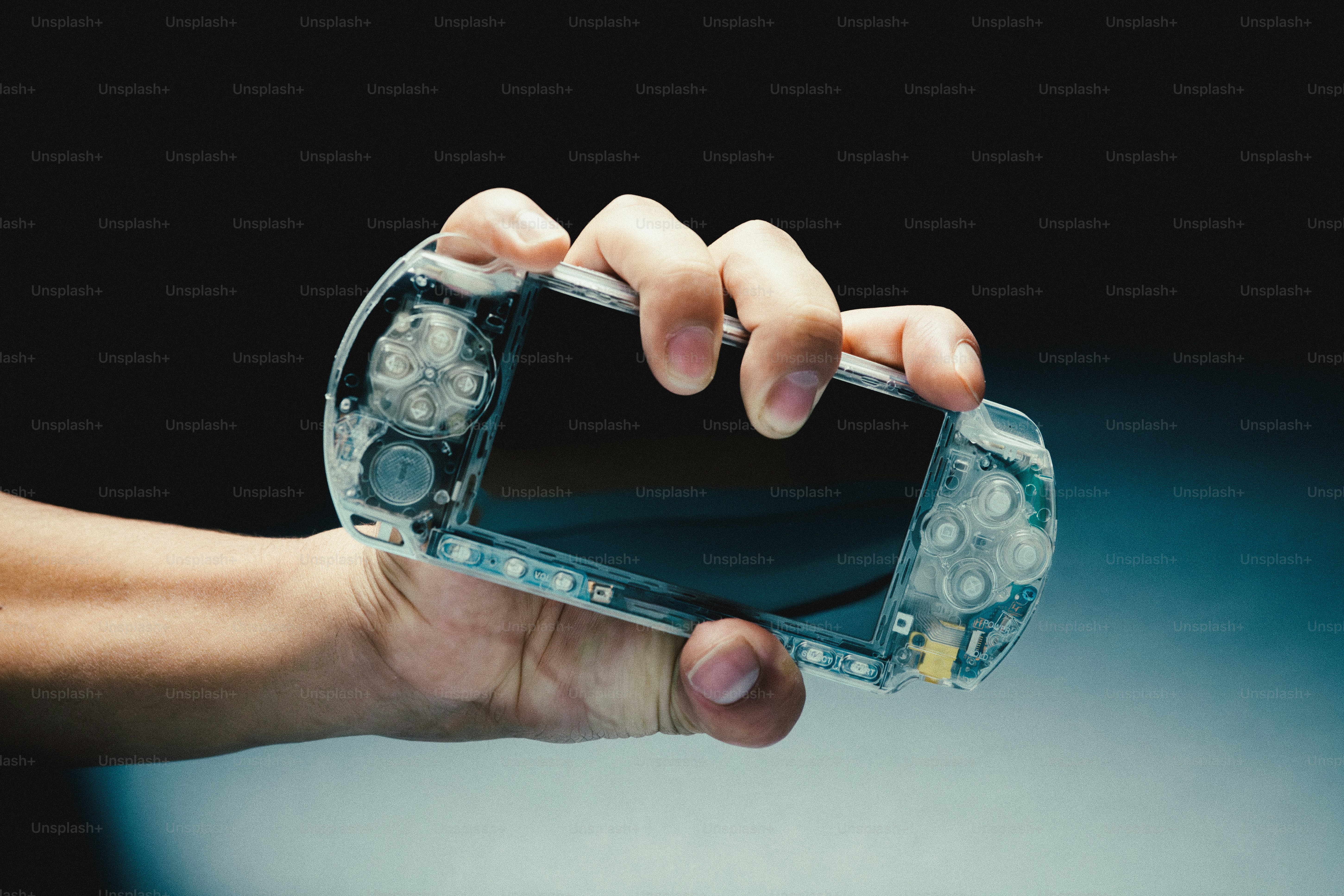 Hand holding a clear portable gaming device photo – Technology Image on ...