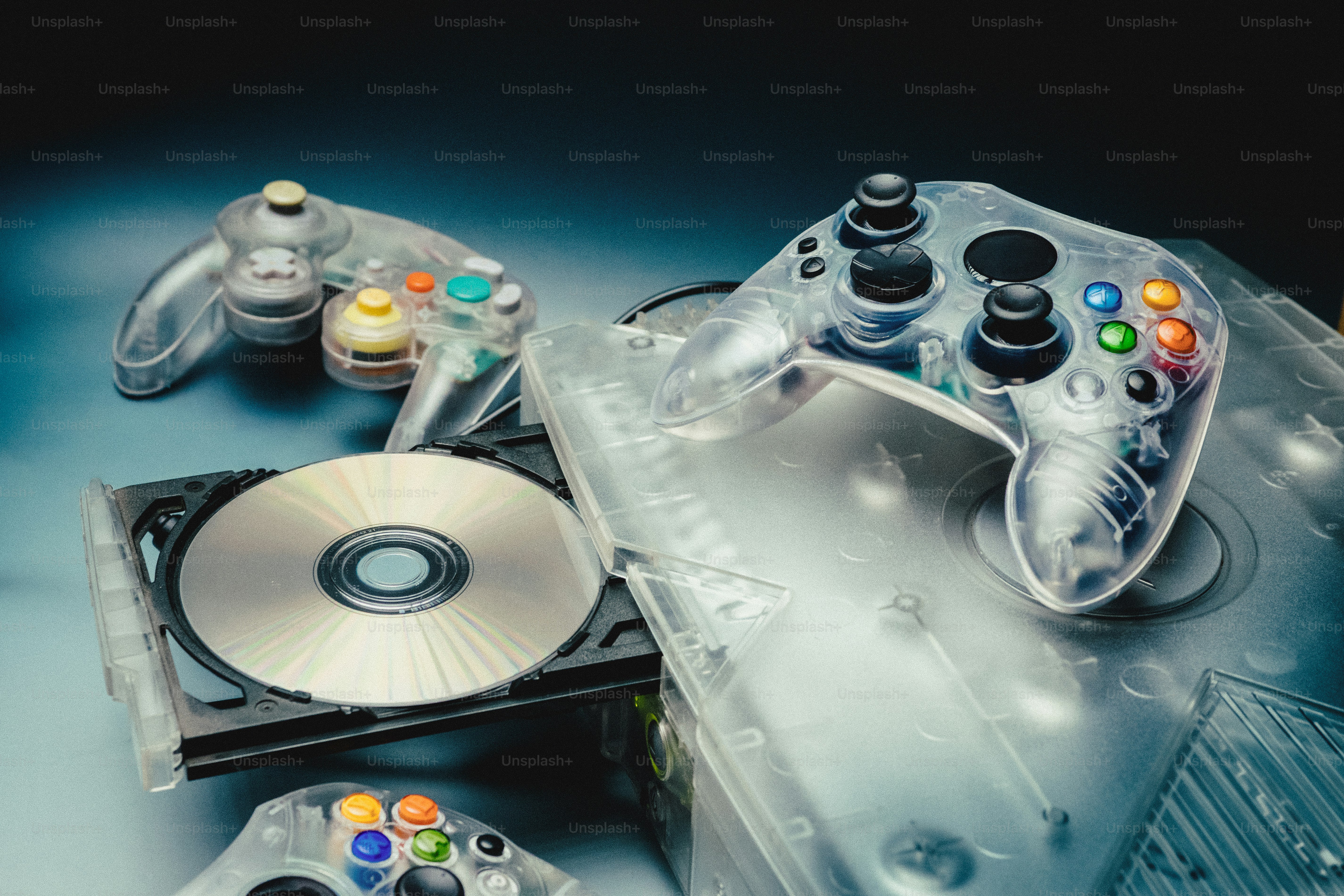 Clear video game controllers and discs on a surface photo – Technology ...