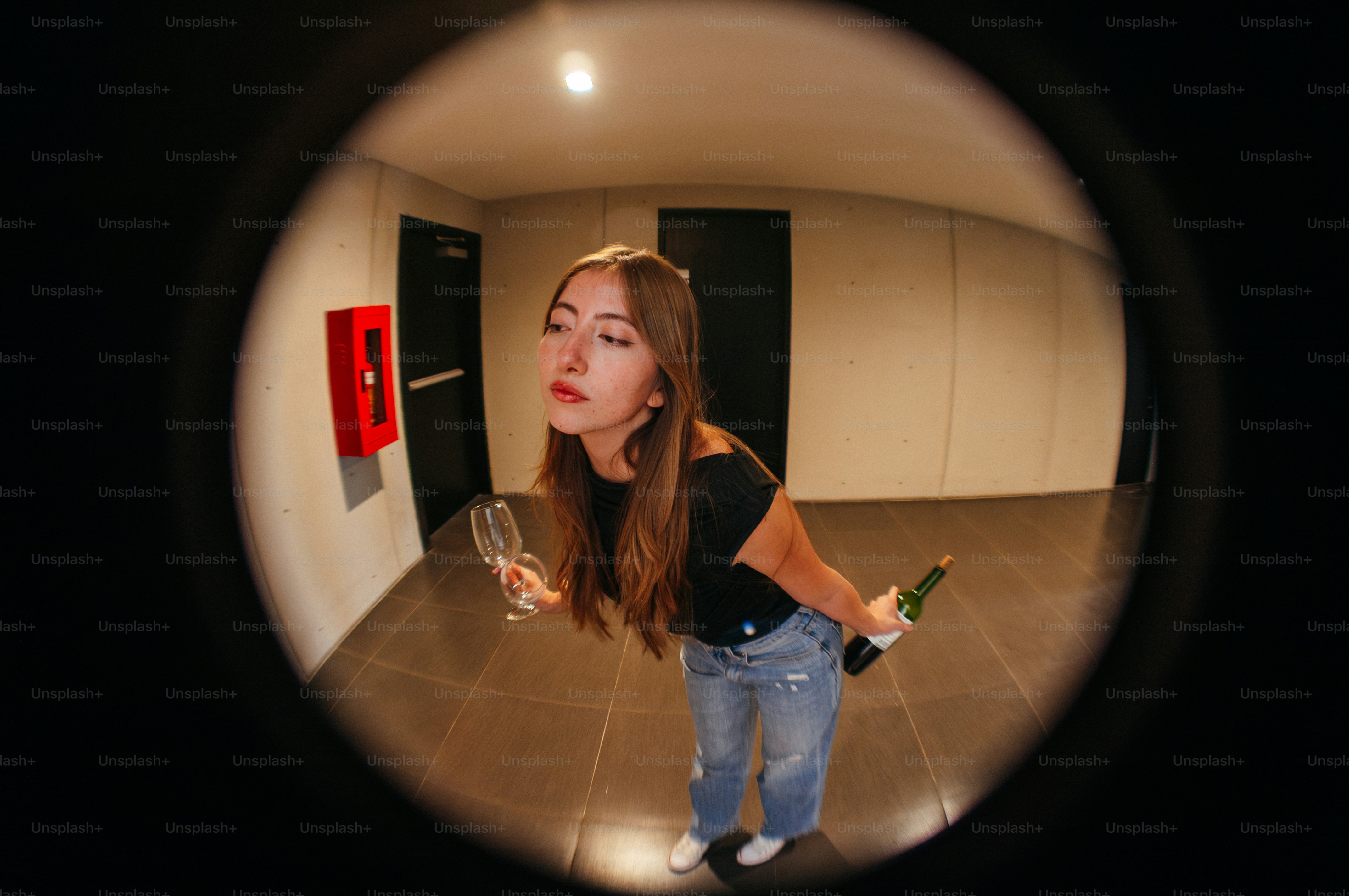Young woman with champagne bottle and glass at door