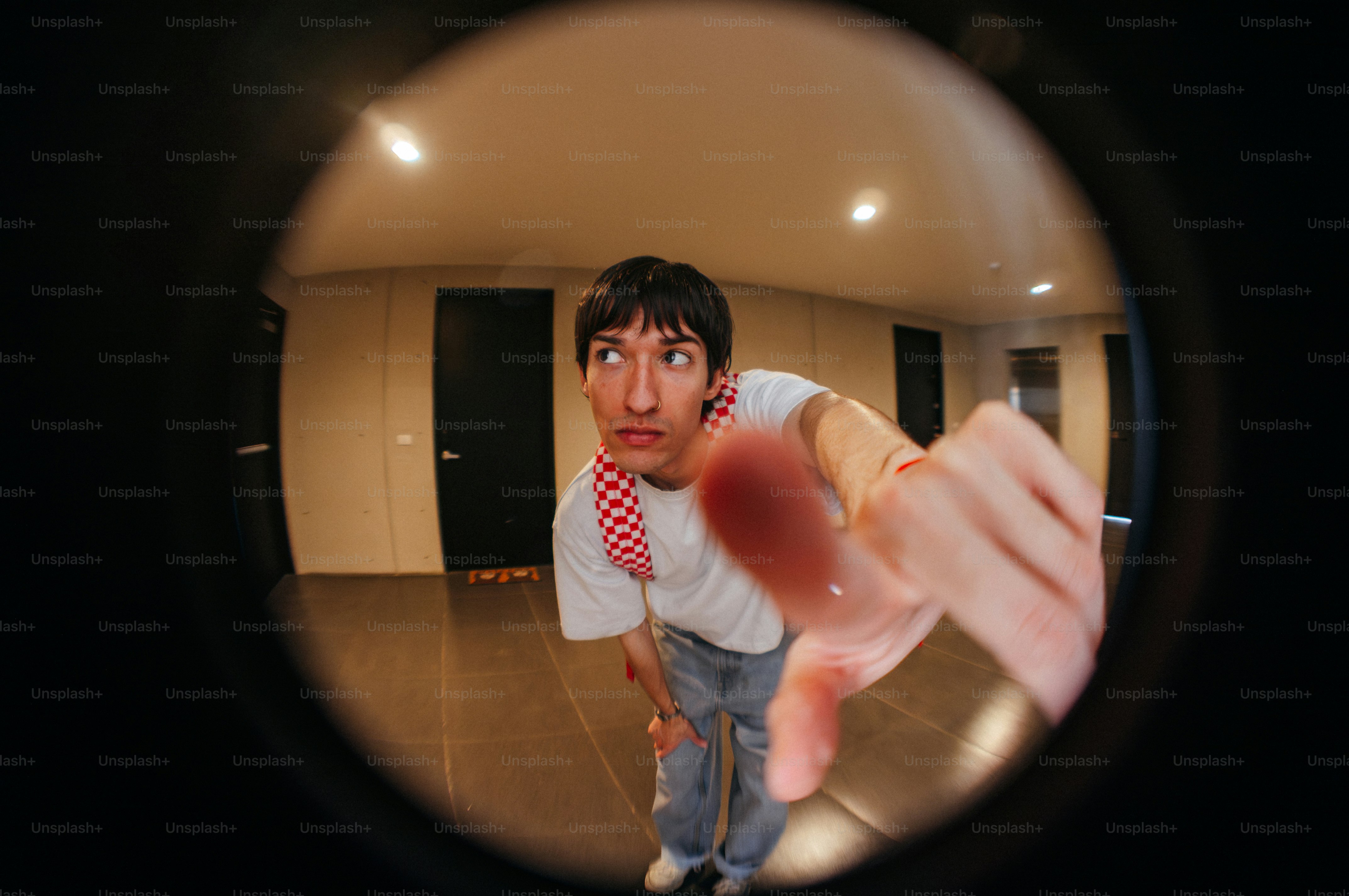 Man looking through peephole with hand reaching out