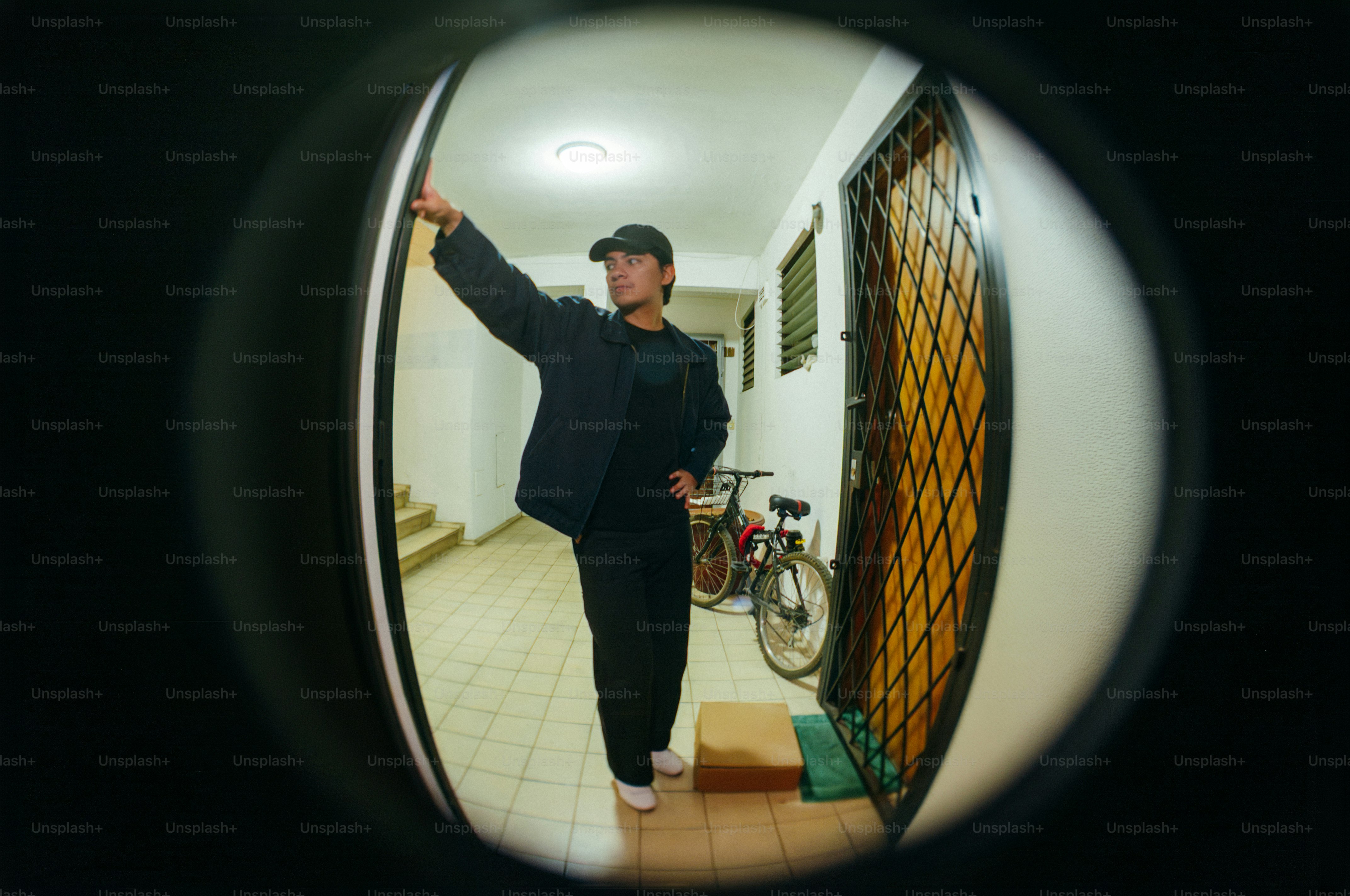 Delivery person rings doorbell at apartment hallway.