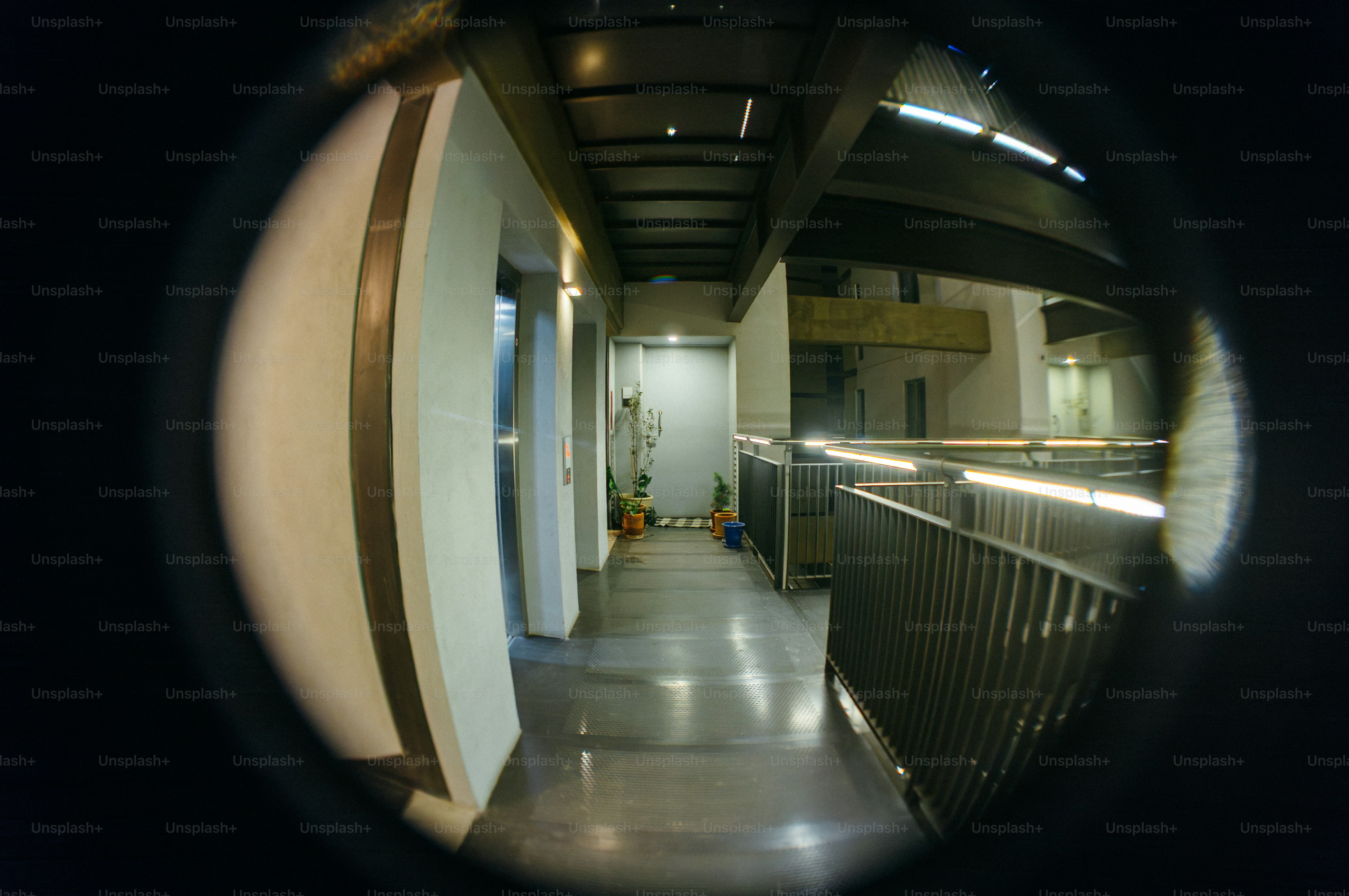 Modern hallway with metal railings and bright lights.