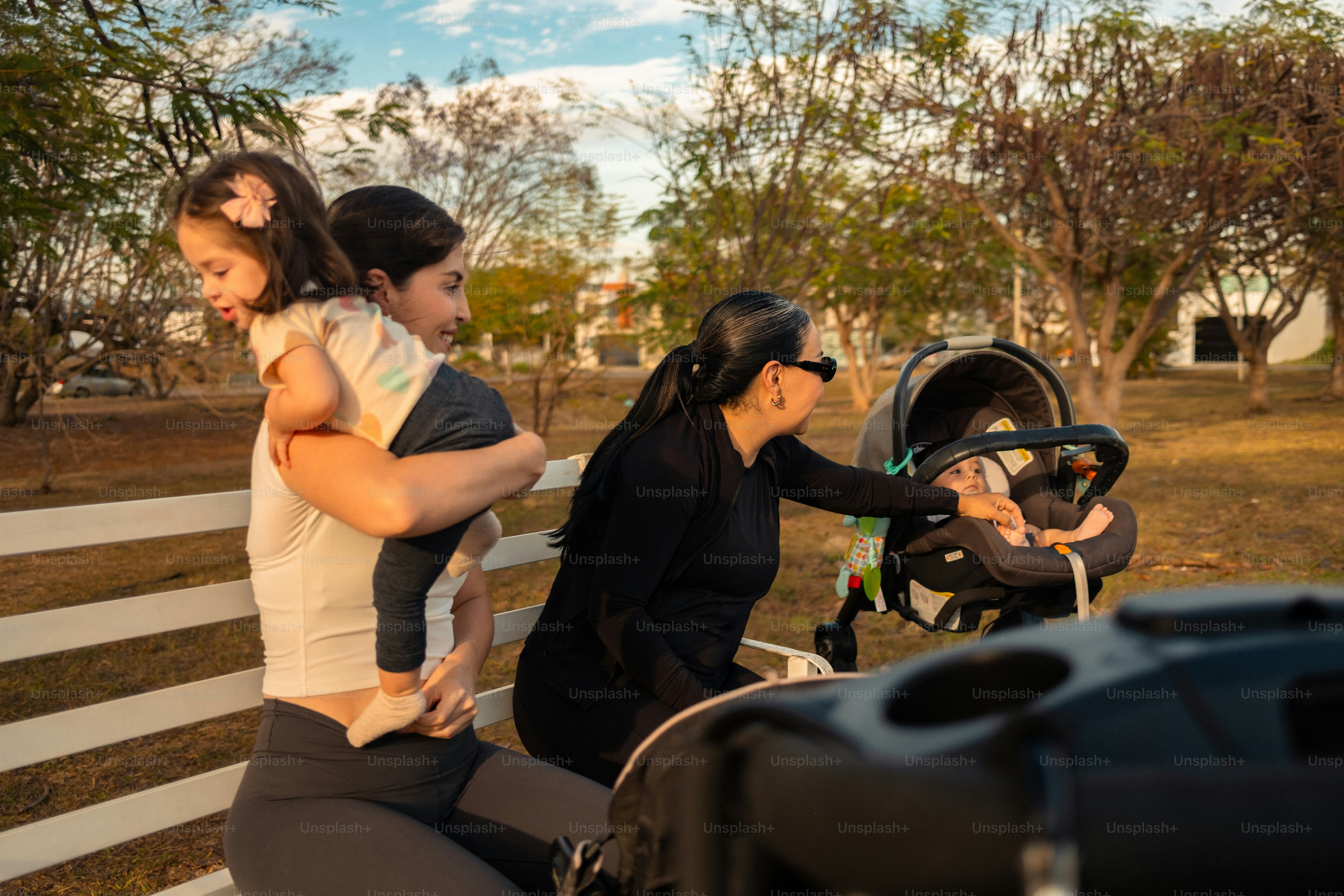 Keluarga dengan kereta dorong di bangku taman