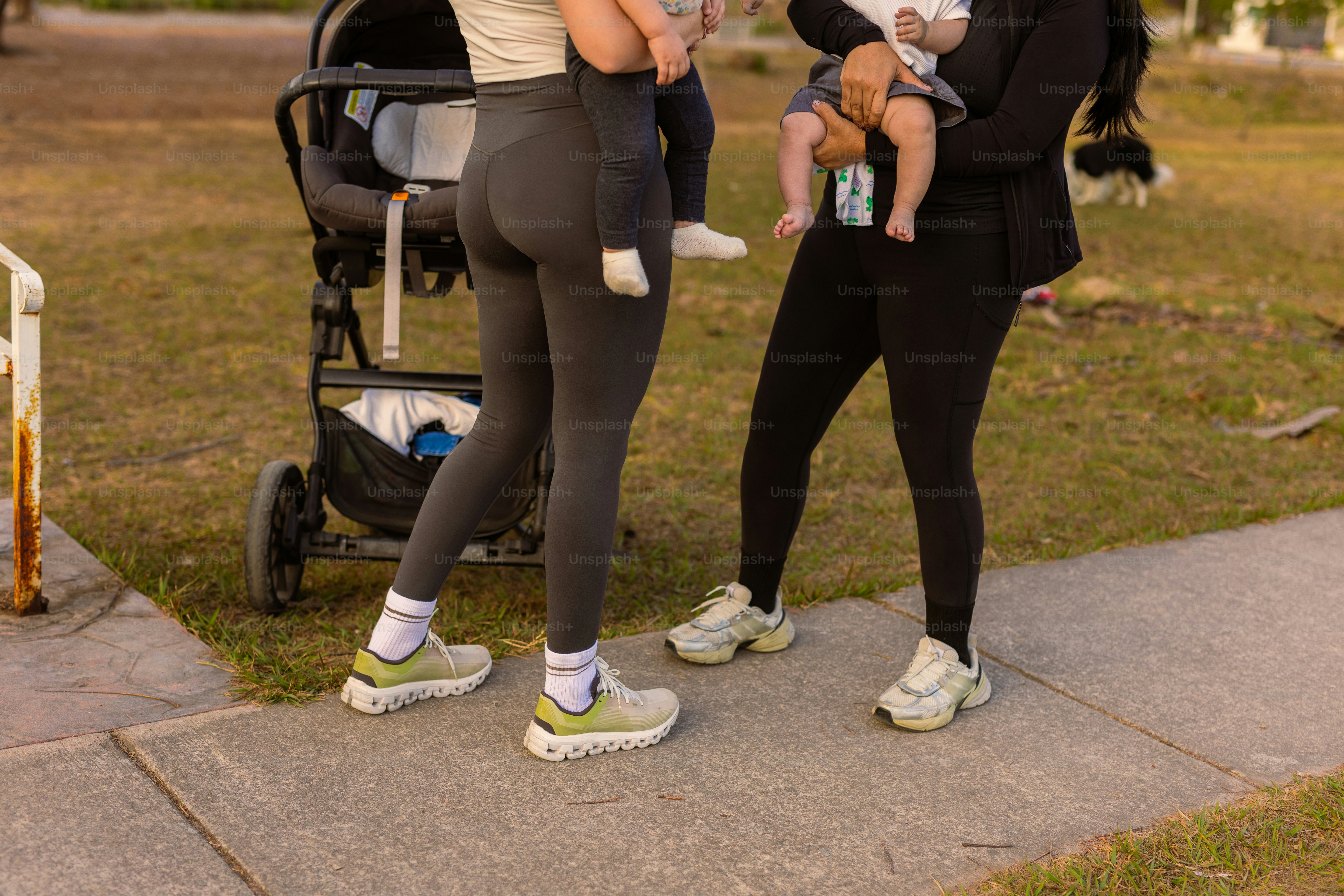 Dua wanita dengan bayi dan kereta dorong di luar ruangan