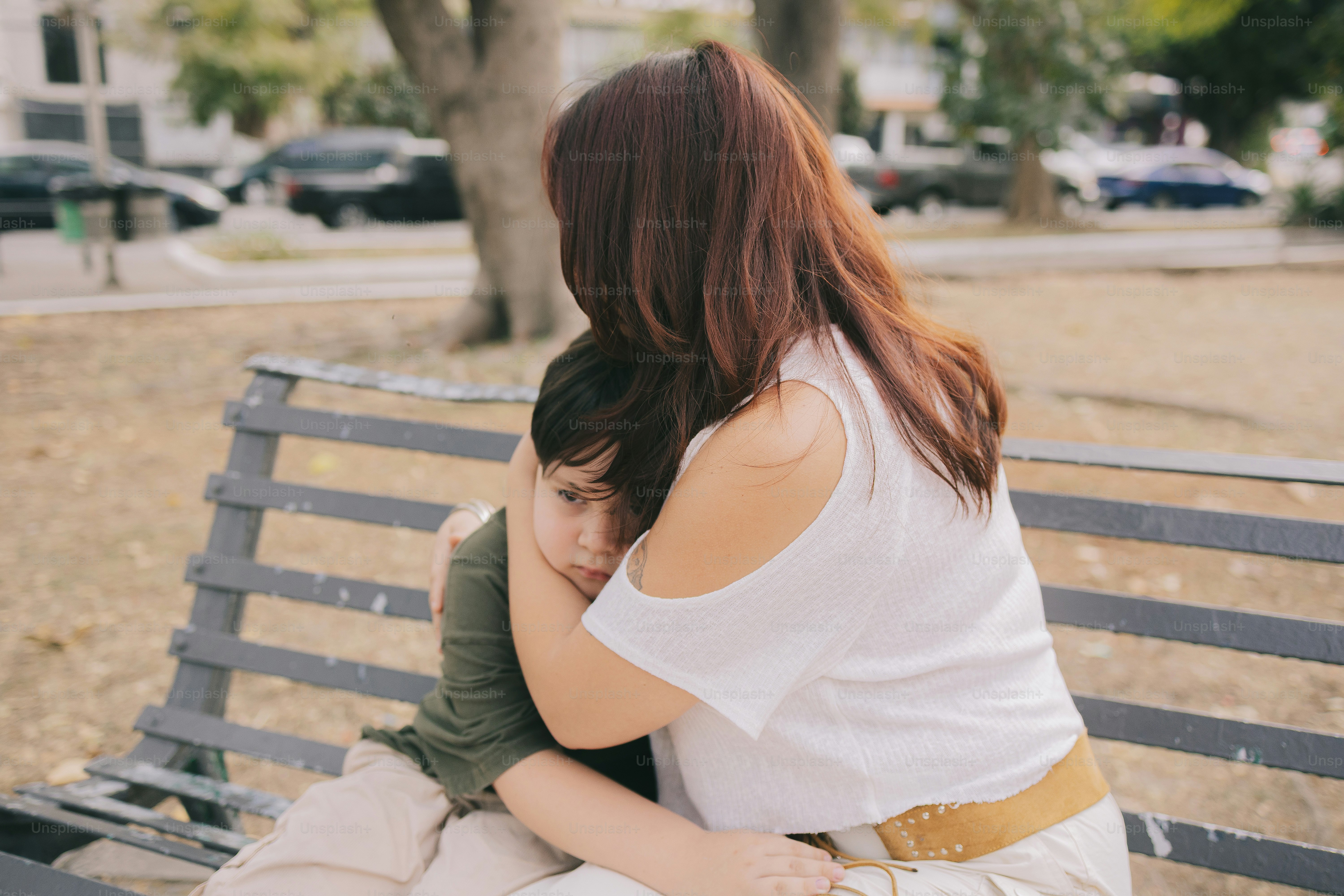 Woman hugging a child on a park bench