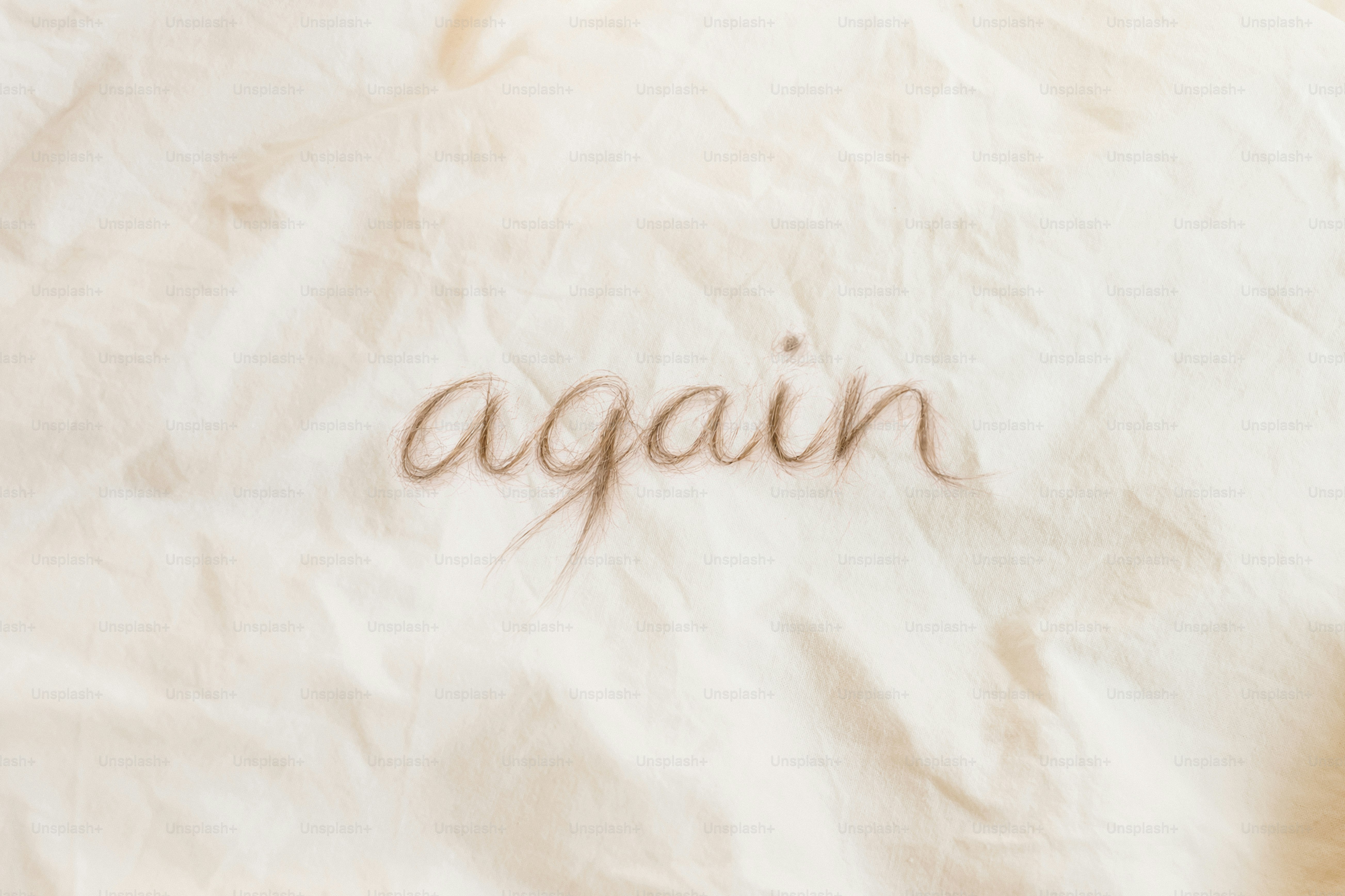 Le mot « encore » écrit sur un tissu froissé