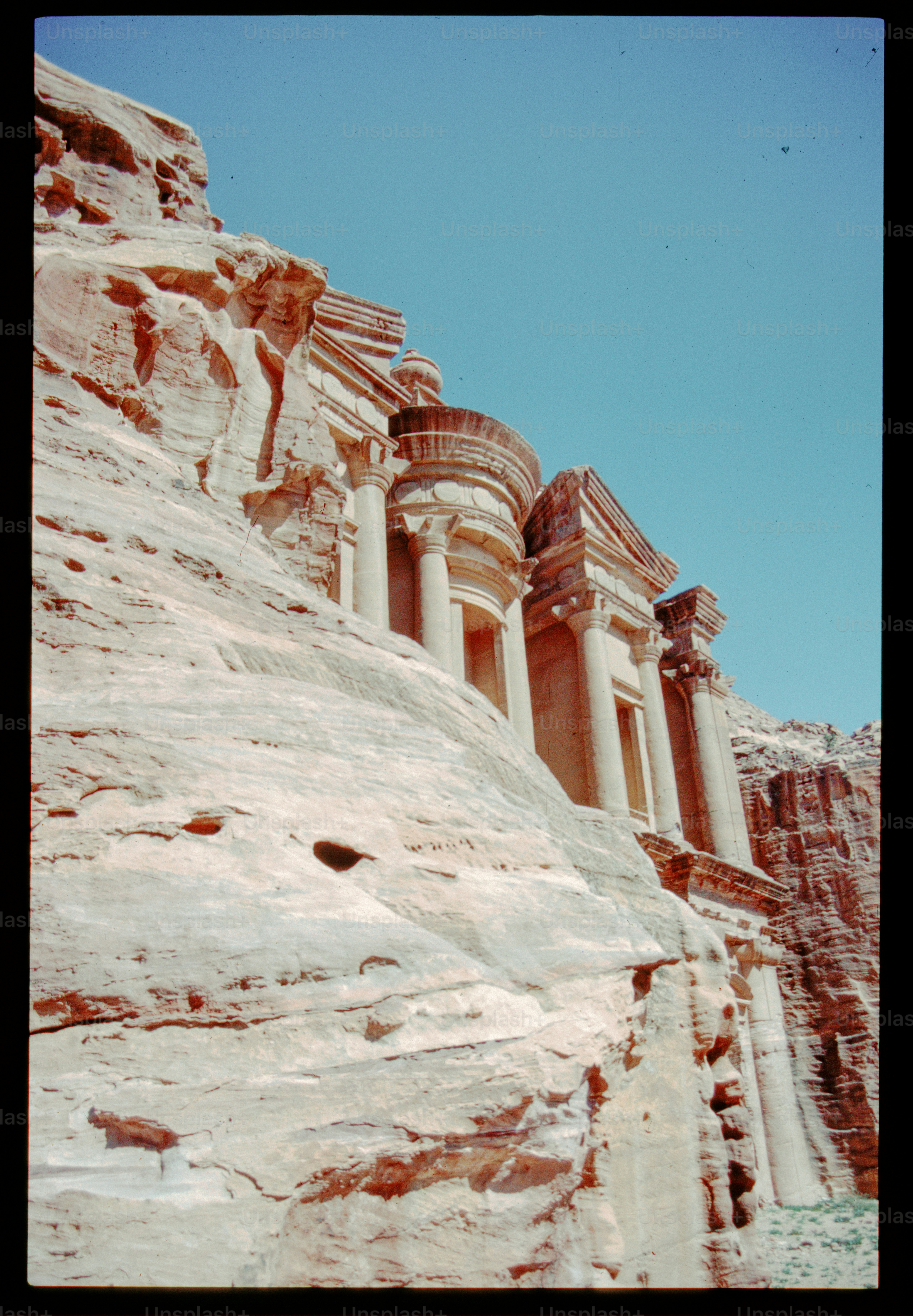 Ancient rock-cut architecture against a clear blue sky photo ...