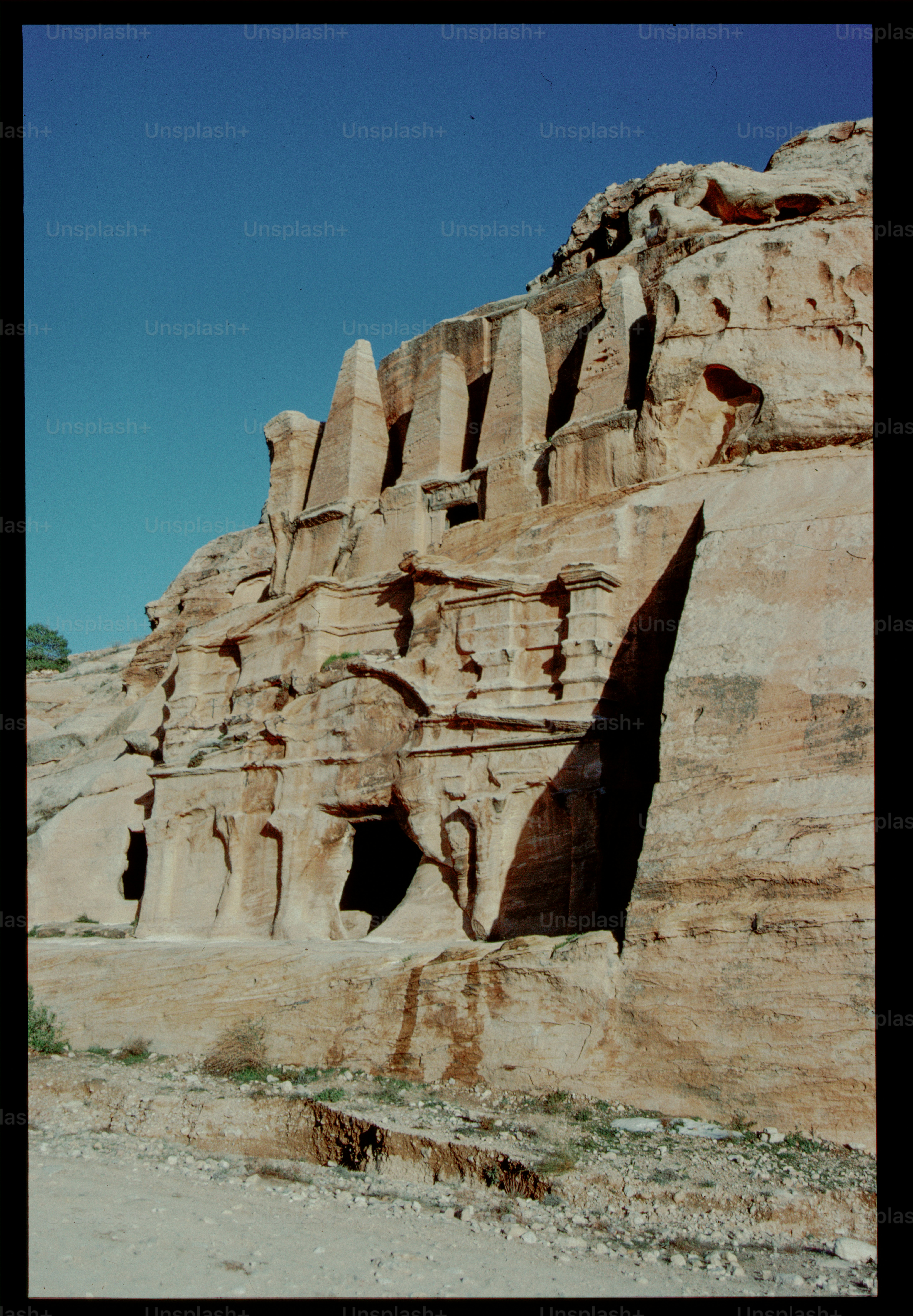 Ancient sandstone structures carved into a narrow canyon photo ...