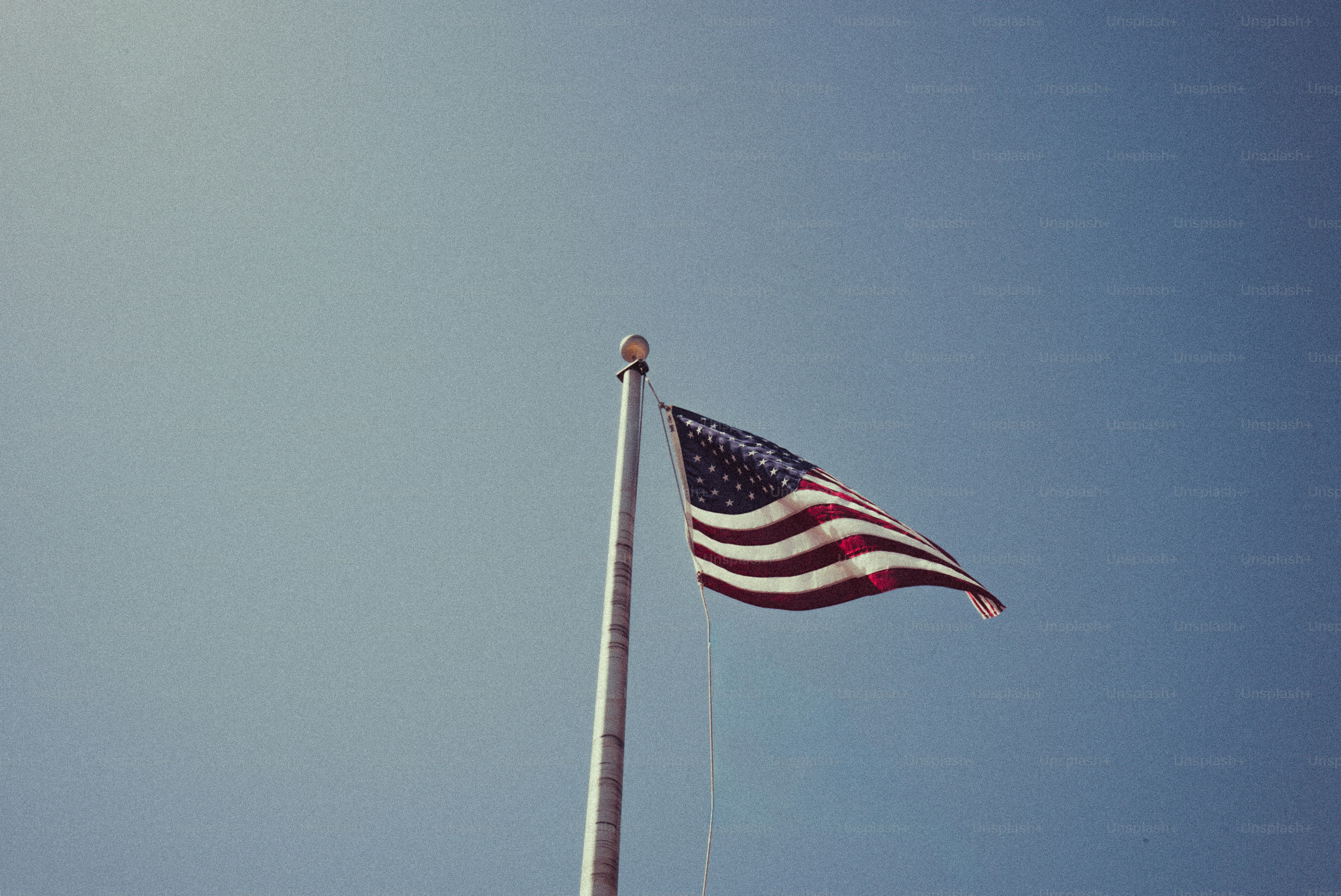 American flag waving on a flagpole against a clear sky