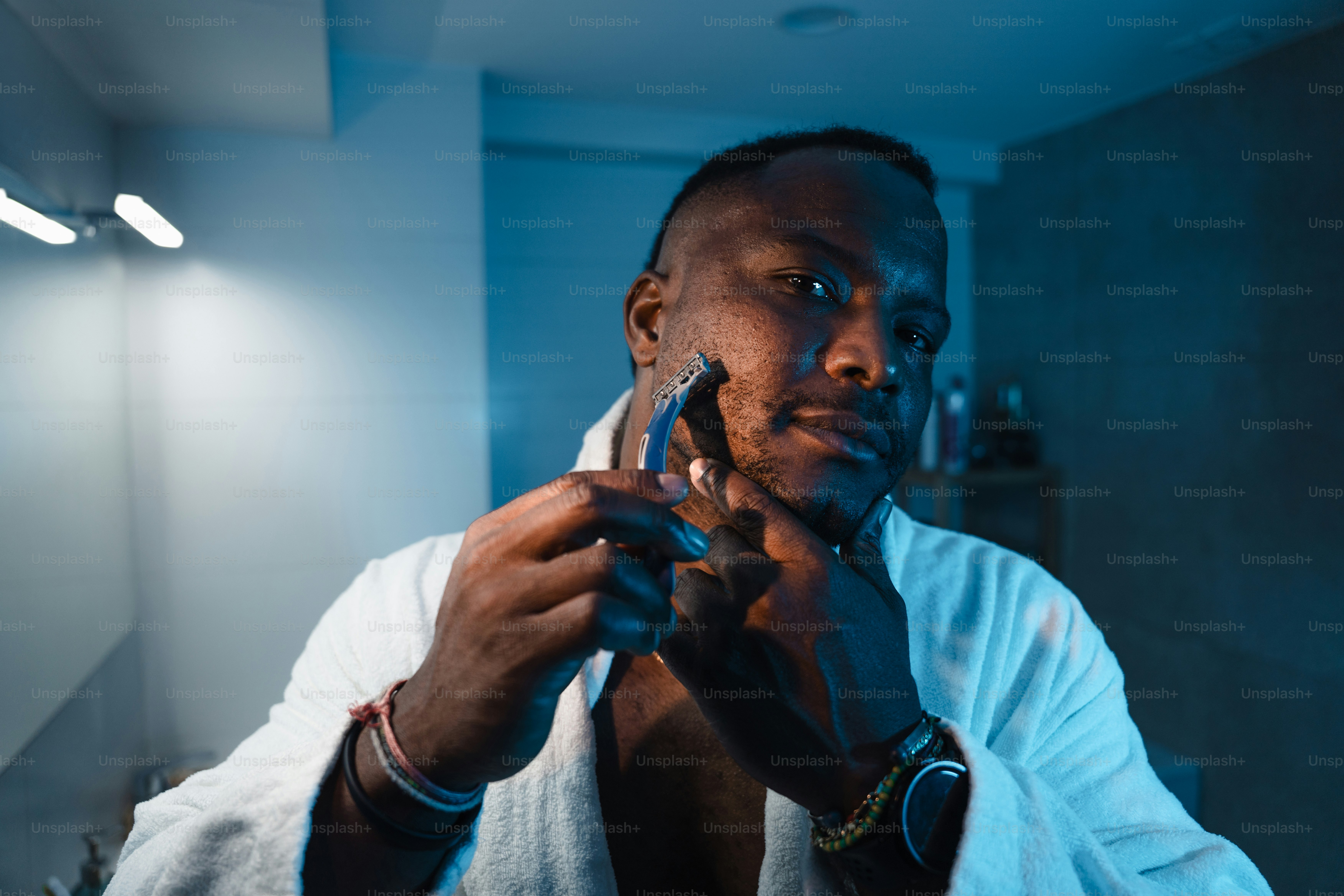 Man in bathrobe shaving his face with razor. photo – Face Image on Unsplash