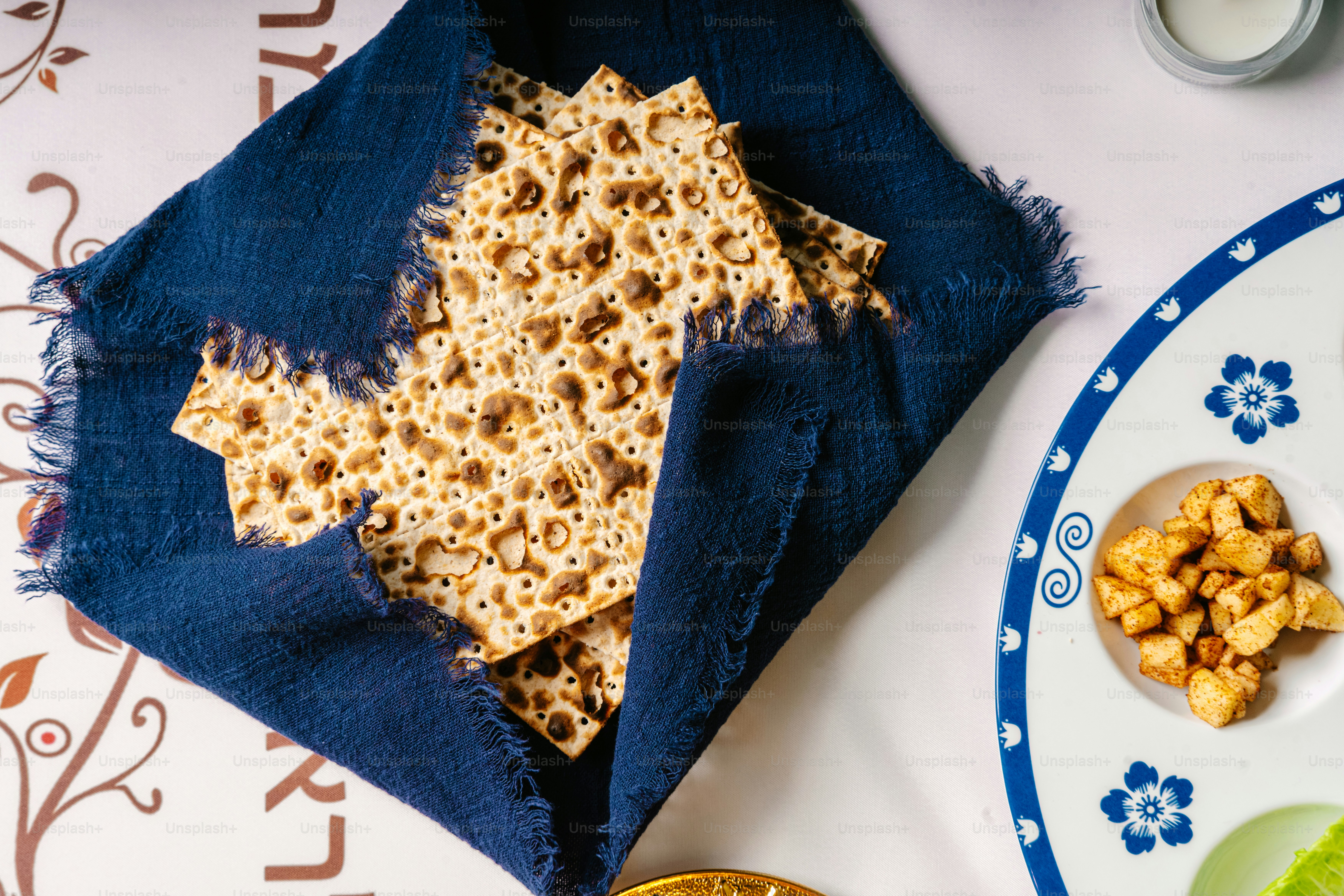 Seder plate with matzah and candle holder on table photo – Passover ...