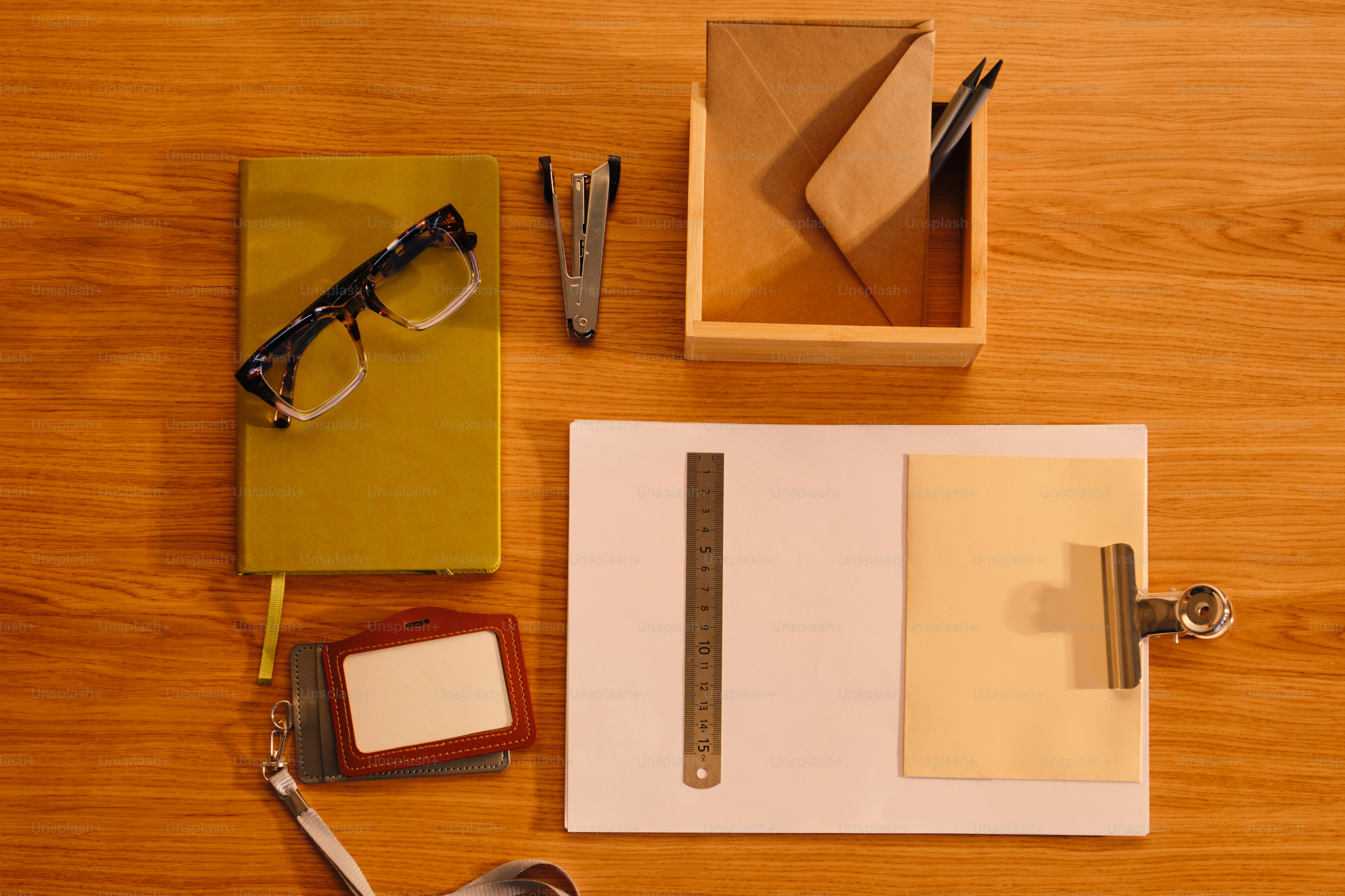 Desk essentials including glasses, notebook, and stationery. photo ...