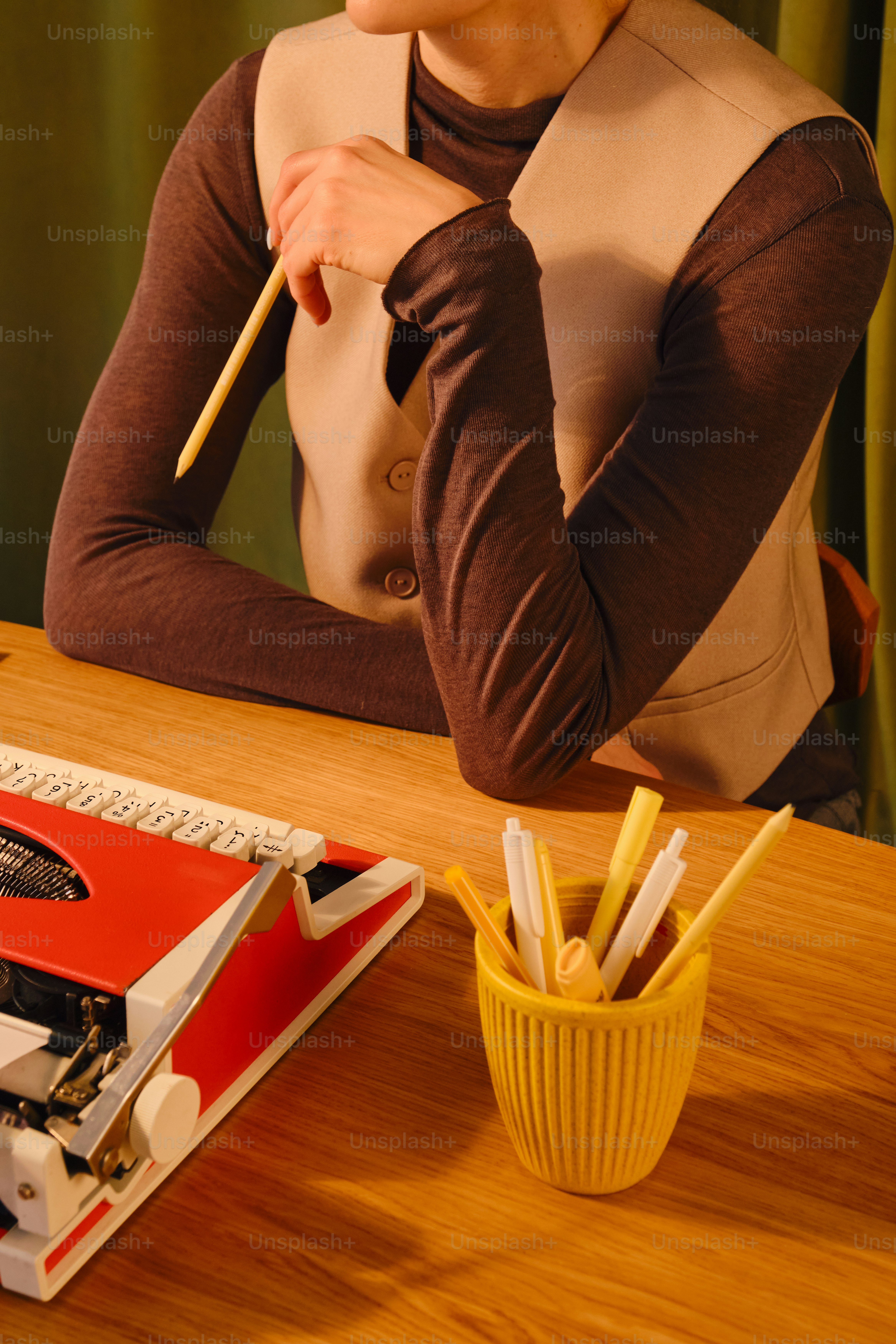 Person at desk with typewriter and pens