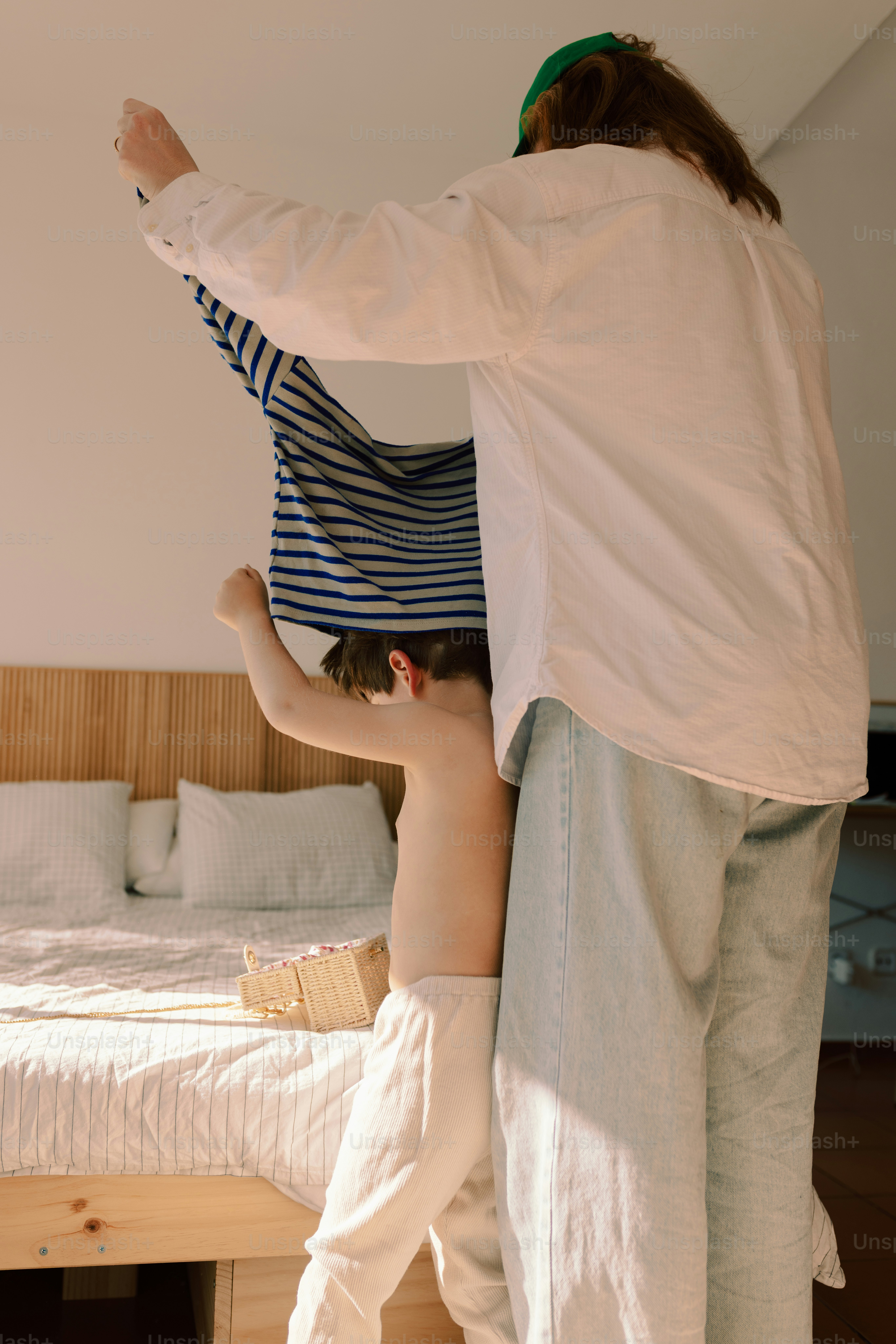 Adulto che aiuta un bambino a indossare una maglietta a righe