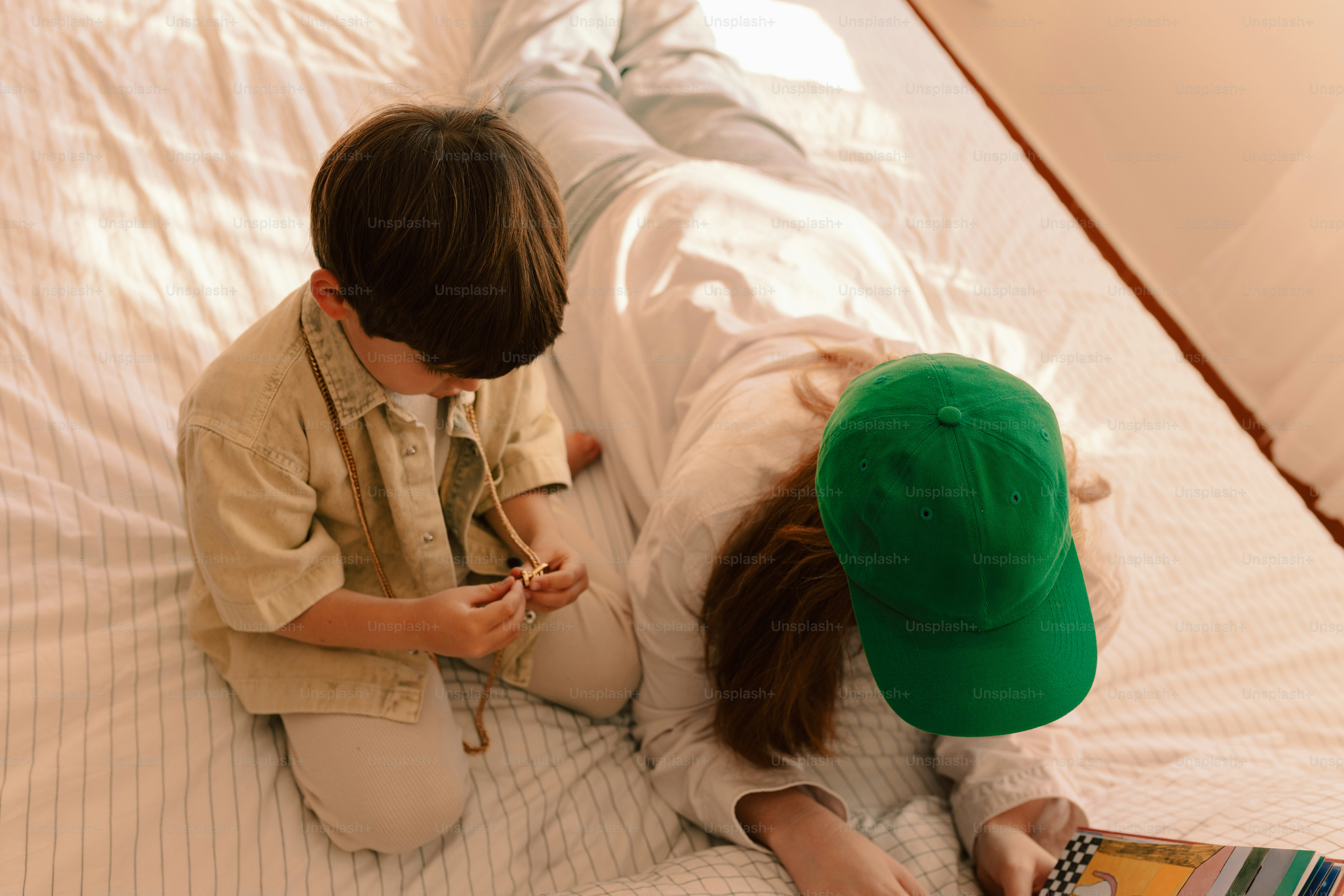 Two children playing on a bed together