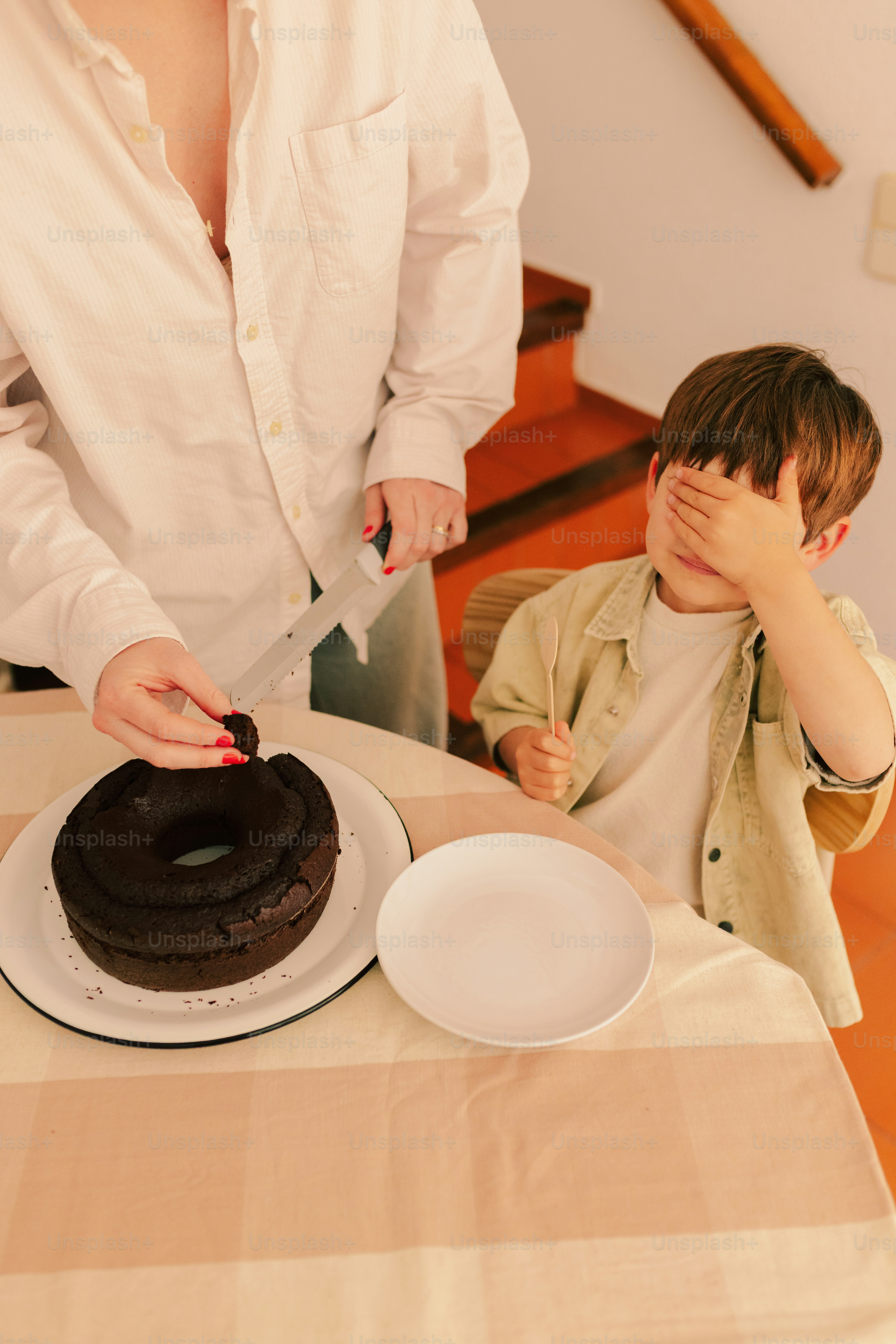Donna che taglia la torta al cioccolato per un ragazzo