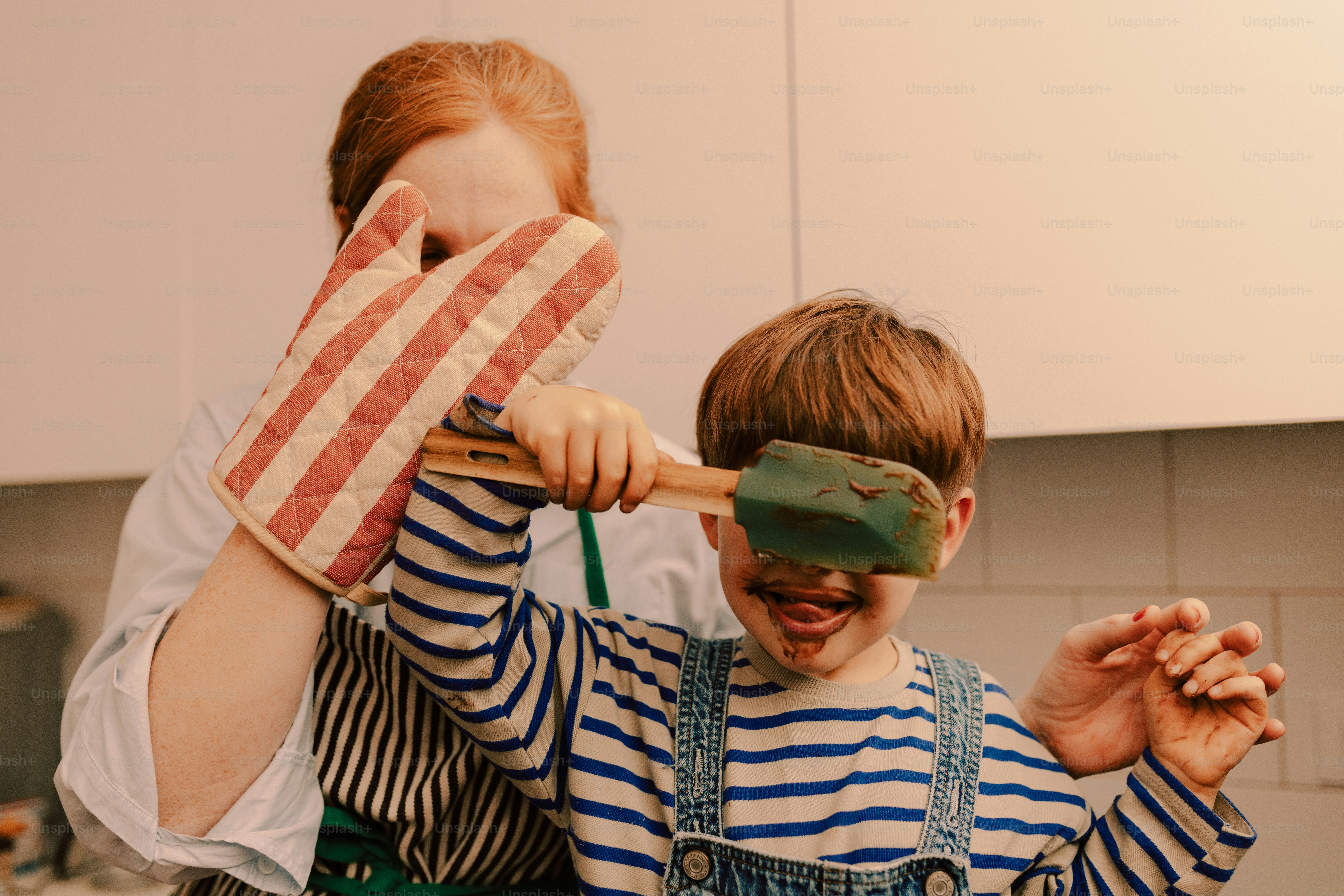 Madre e bambino che cucinano, bambino coperto di cioccolato